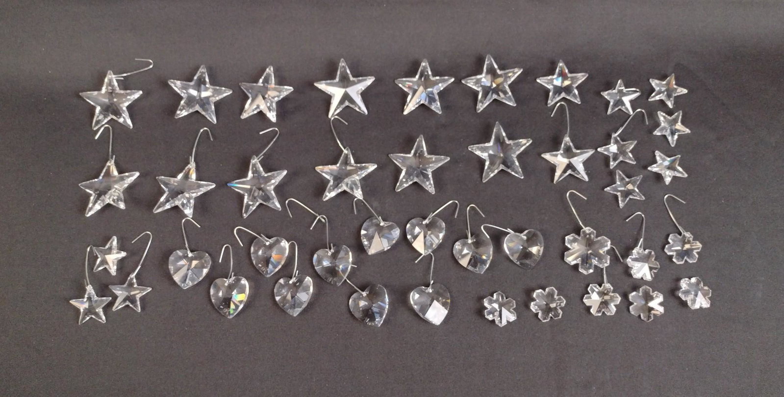 42 Swarovski Ornaments: Includes 11 hearts, 8 flowers, and 23 stars. 1 to 1-3/4" wide x 1" to 2" high. MEG From the estate of Robert Harman. IMPORTANT: Before bidding, please read the terms and conditions. When you registere
