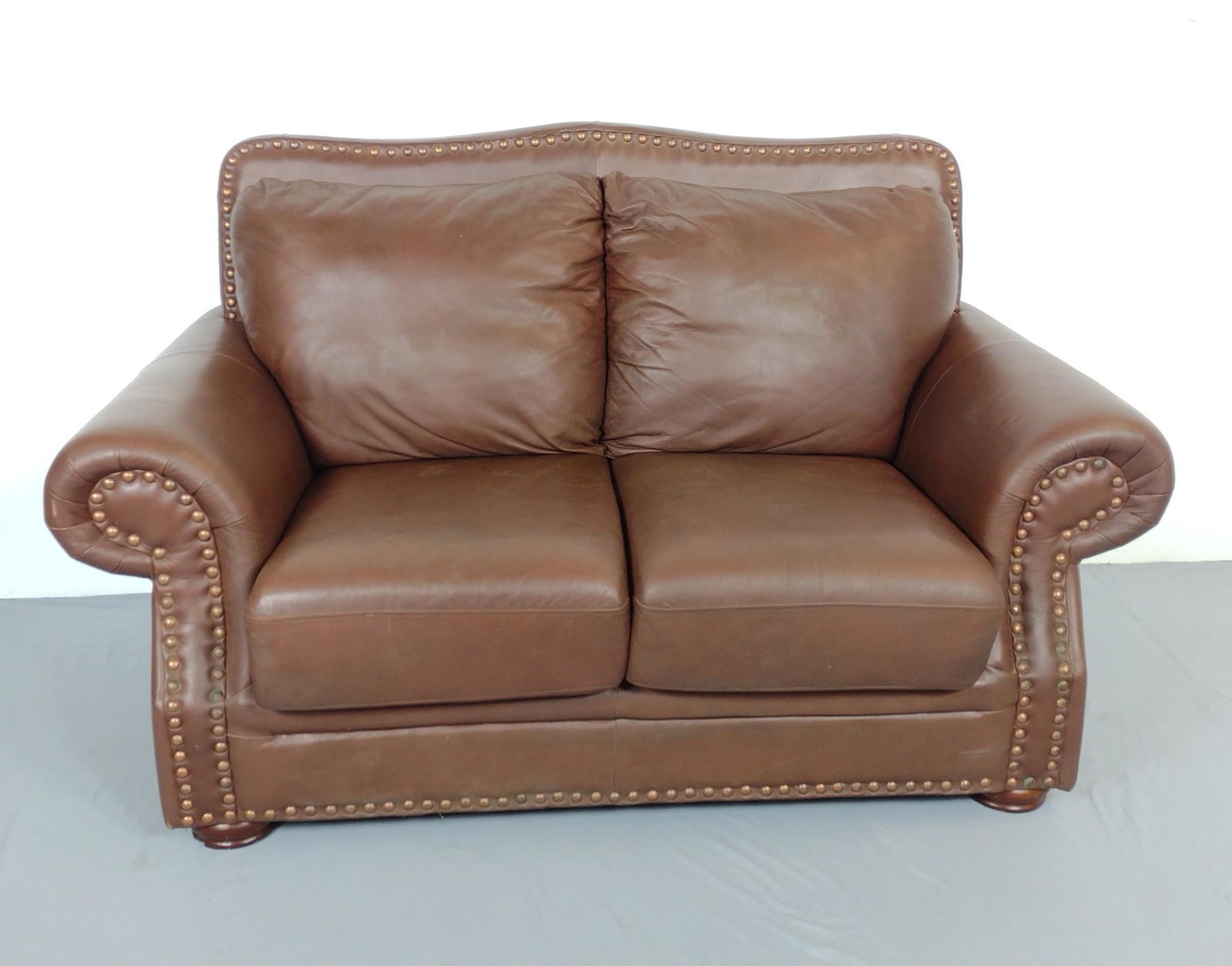 Leather Loveseat: 69" wide X 37" deep X 40" high. Has some areas of discoloring. MG. IMPORTANT: Before bidding, please read the terms and conditions. When you registered for the auction you agreed to these terms and wi