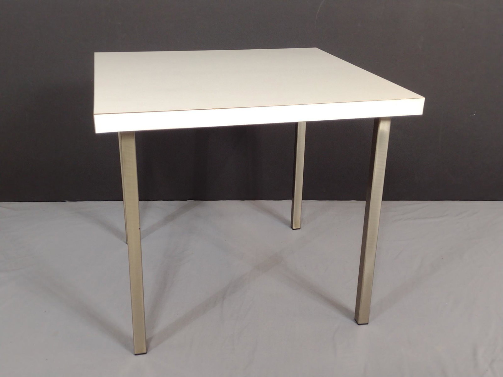 Formica Top Side Table: 24" wide X 24" deep X 21-1/4" high. Has some light scratches. MG. IMPORTANT: Before bidding, please read the terms and conditions. When you registered for the auction you agreed to these terms and wil