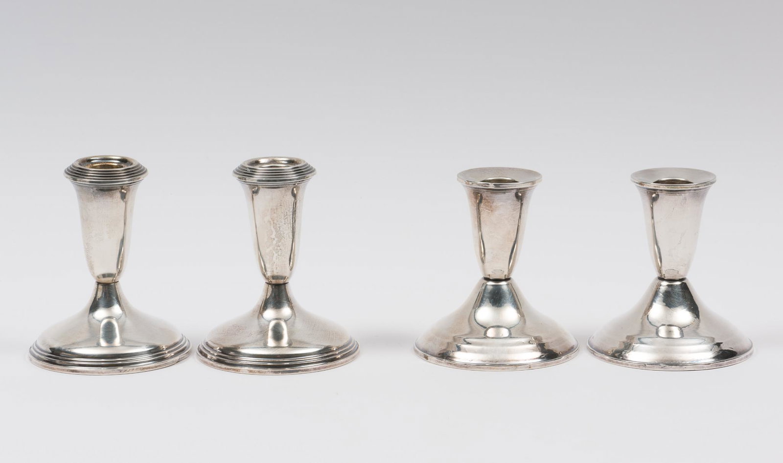 4 Weighted Sterling Candle Holders: Includes 2 Empire Sterling and 2 Duchin Creations. All marked weighted sterling on bottom. 3-3/4" and 4-1/8" high and 3-1/2" and 3-3/4" wide. Light scuffing and wear as expected with age. AJ. IMPORTAN