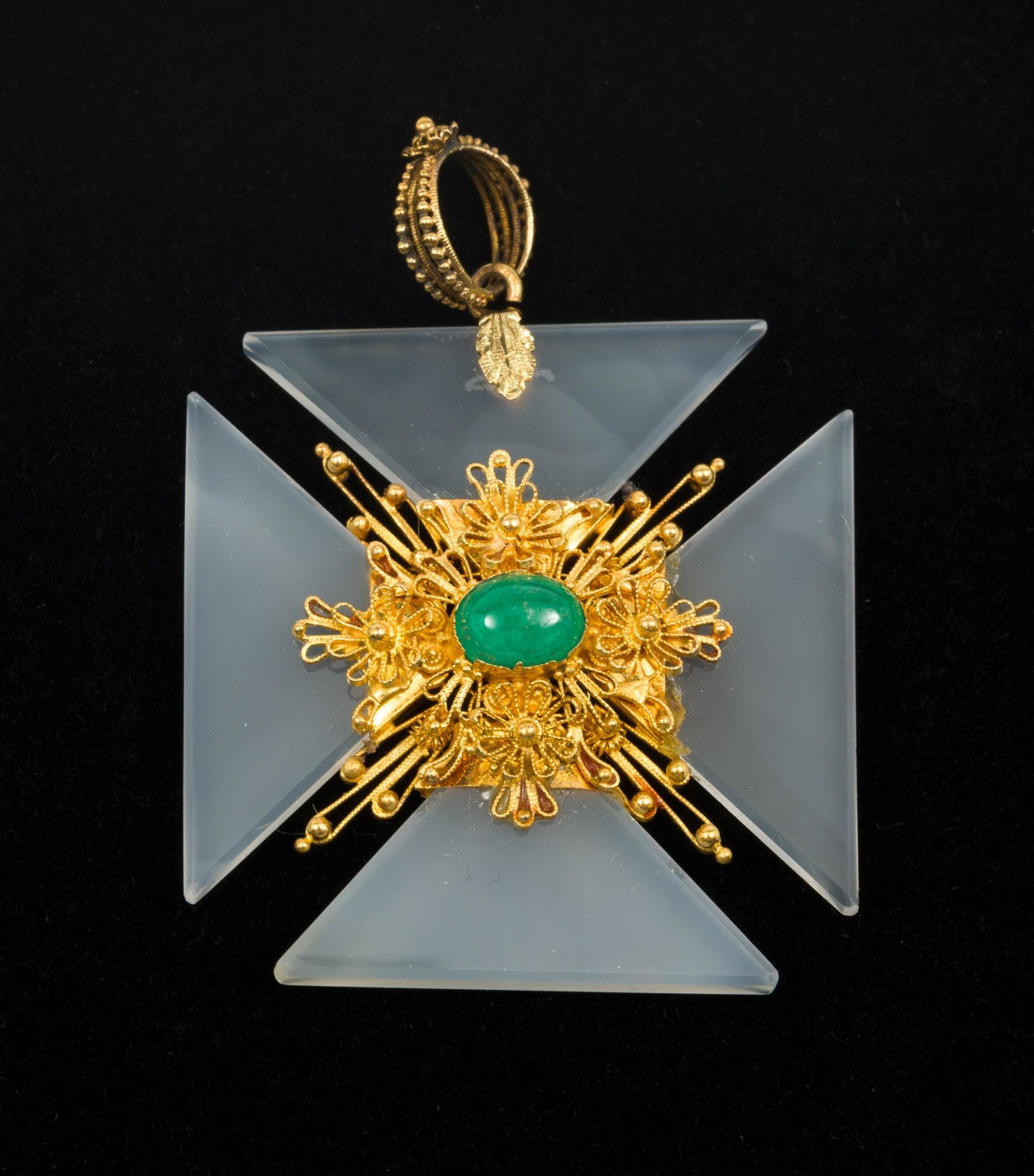 Georgian Chalcedony, Emerald, and 18K Gold Maltese Cross Pendant: Polished chalcedony cross set with central floral motif wrought in 18K (tested) gold with central approximately .60 carat emerald cabochon. Compartment on reverse is vacant. 2" long (with bale), 1-3/8