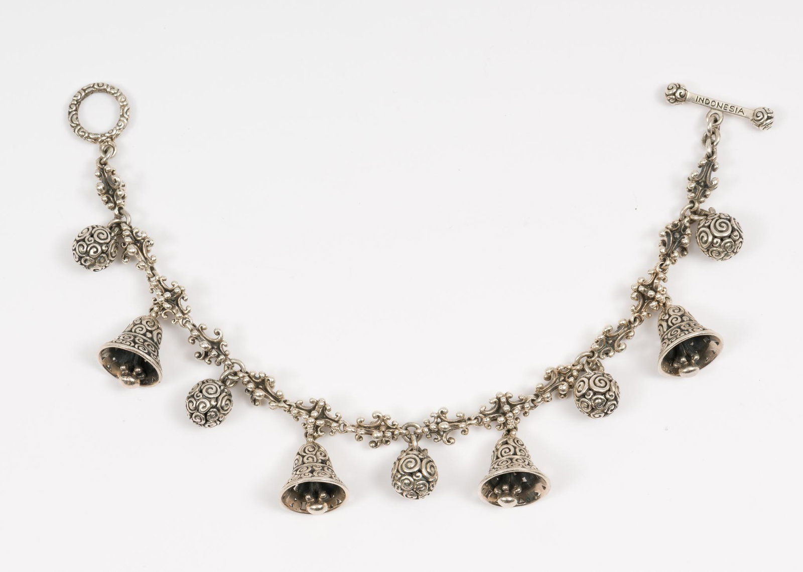 Indonesian Sterling Bell Charm Bracelet: Marked sterling bracelet marked Indonesia with bell and ball charms. 7" long, charms 3/8" and 1/2" long. MH. IMPORTANT: Before bidding, please read the terms and conditions. When you registered for th