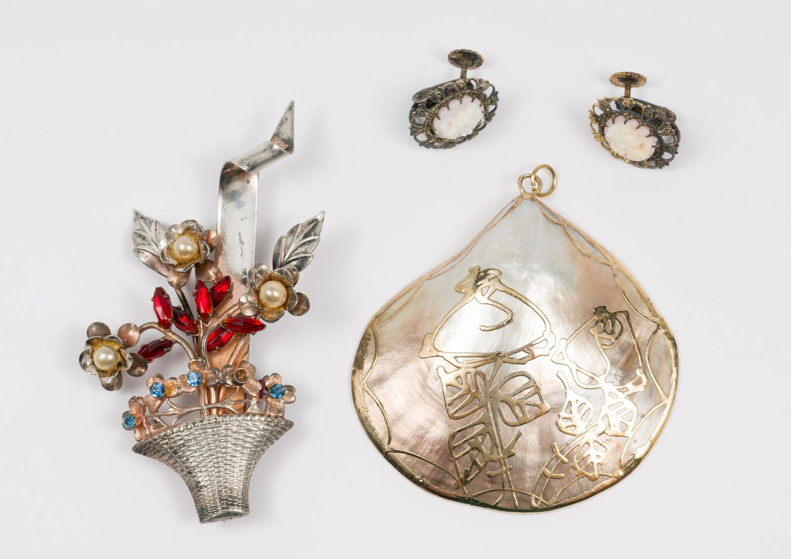 Sterling Earrings, Pendant, Brooch: Sterling overlay mother of pearl pendant 2-1/2" long. marked sterling bouquet brooch 3" high. Marked sterling cameo screwback earrings 3/4" long. MH. IMPORTANT: Before bidding, please read the terms a