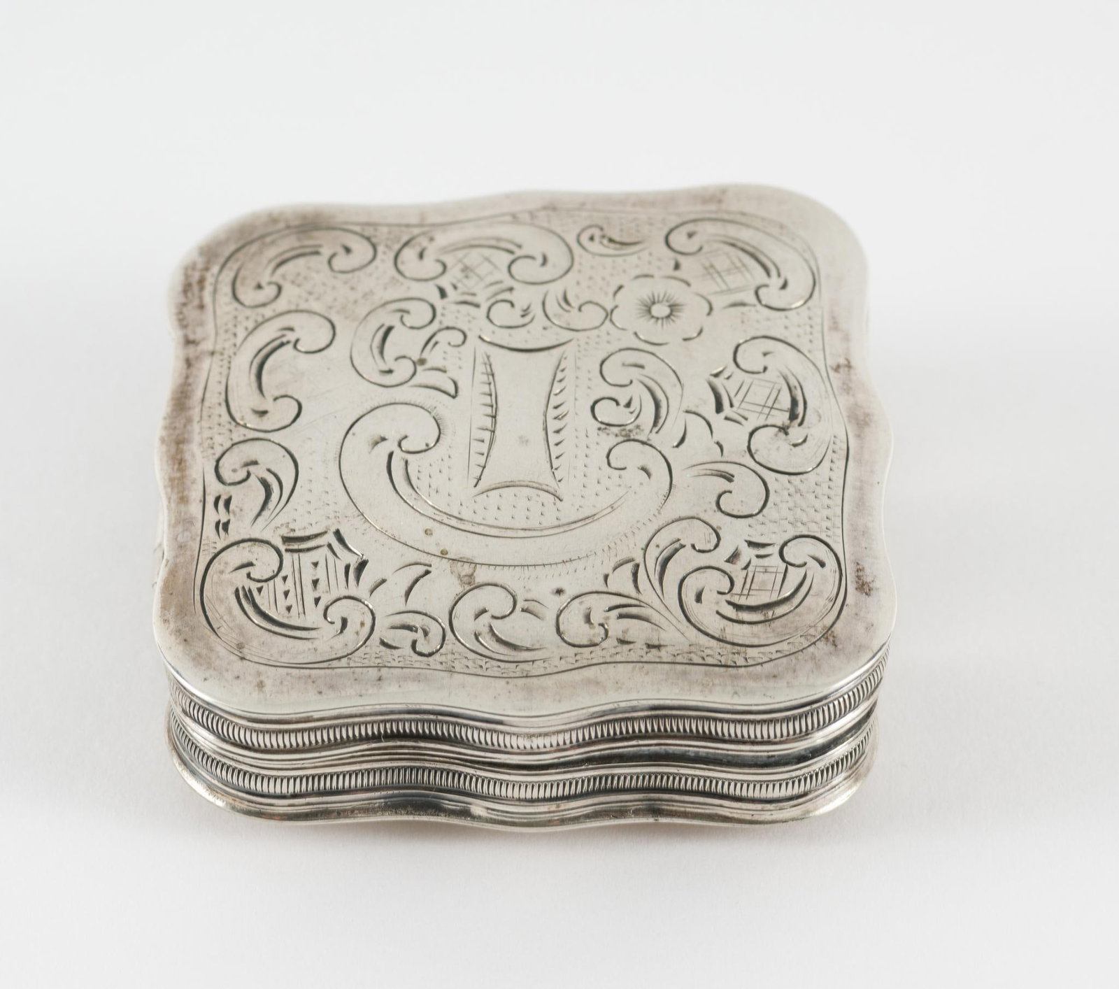 19th Century Sterling Snuff Box: Engraved snuff box. 1-7/8" wide x 1-7/8" high. Sterling hallmarks inside box and lid. 0.7 total ozt. Light scuffing and wear as expected with age and careful use. AJ.