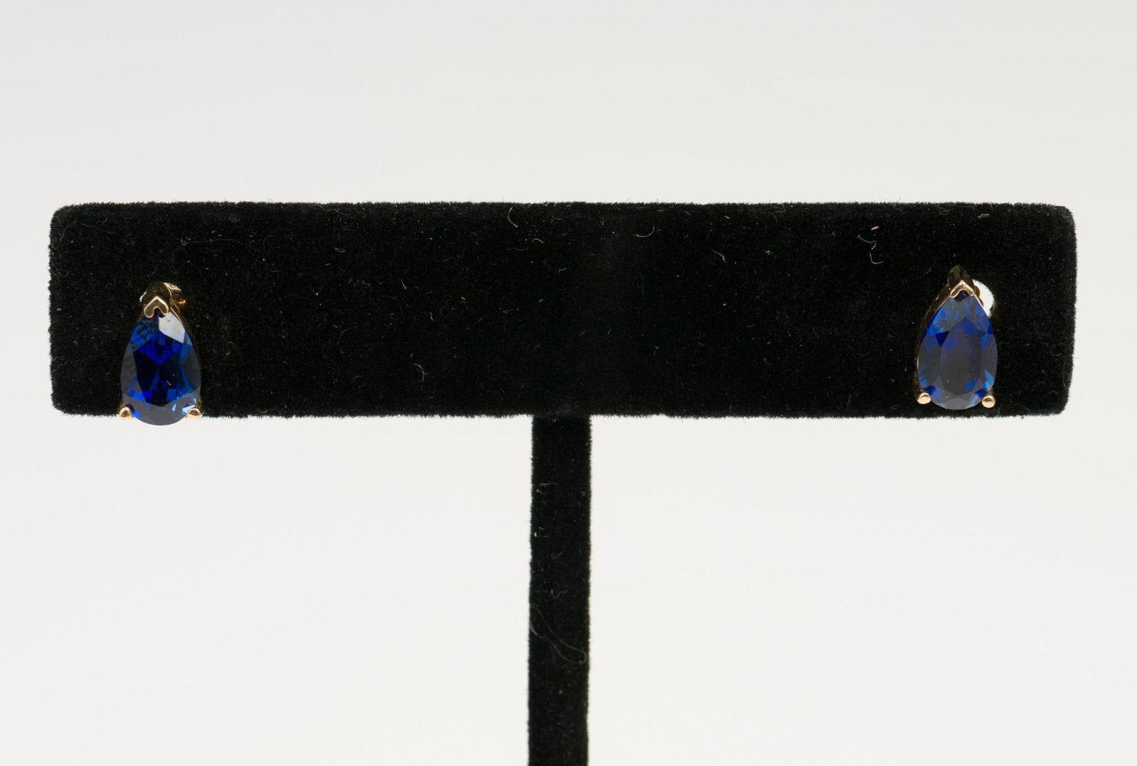 14K Gold and Sapphire Errings: Marked 14k pierced earrings each set with pear cut blue sapphire. 5/16" high. 1.0 total dwt/1.6 g. AJ/EK.
