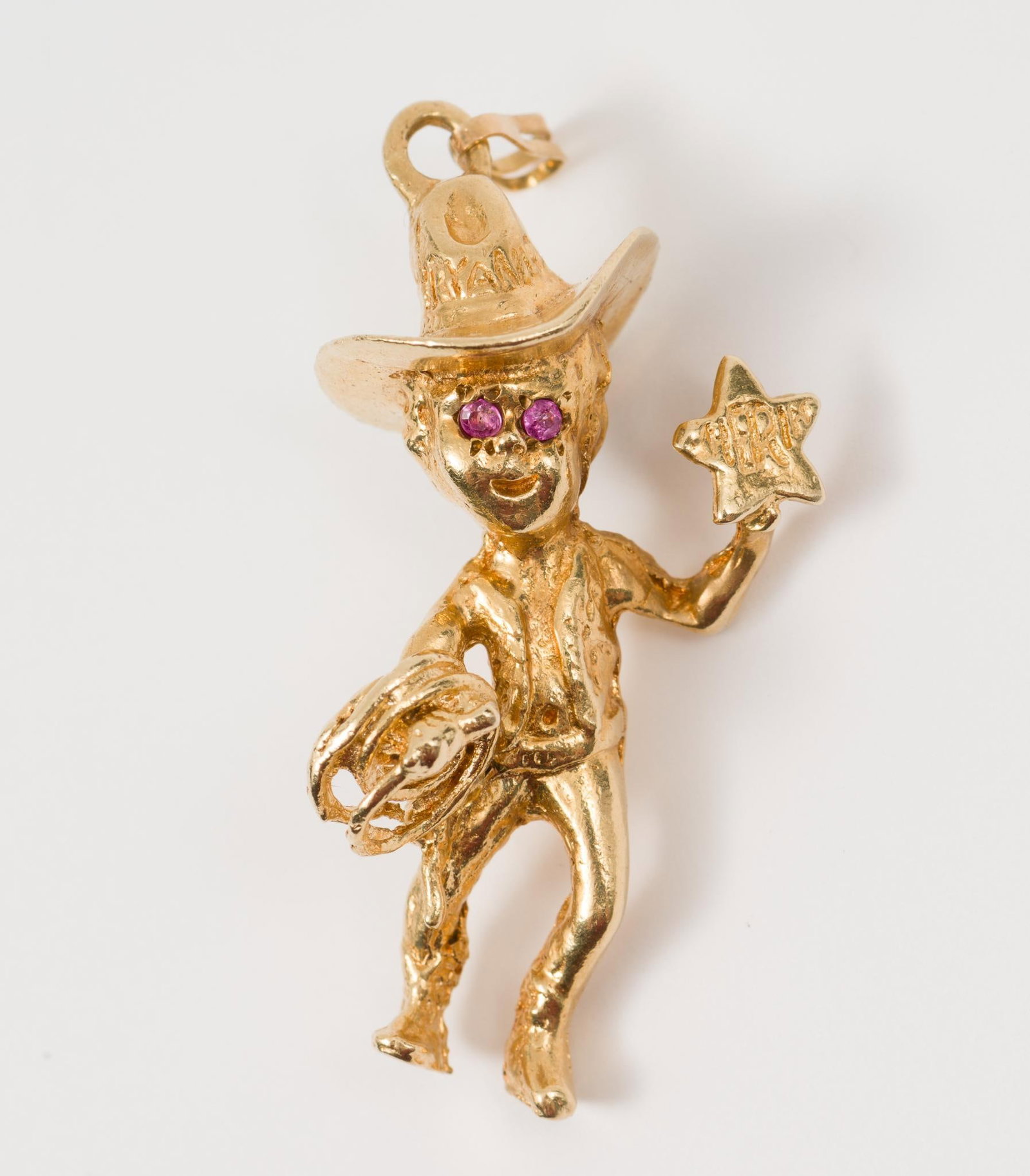 14K Gold & Pink Sapphire Cowboy Charm: Cowboy charm with round pink sapphires for eyes. Tested 14k gold. 1-1/2" high. 6.7 total dwt/10.4 g. AJ/EK