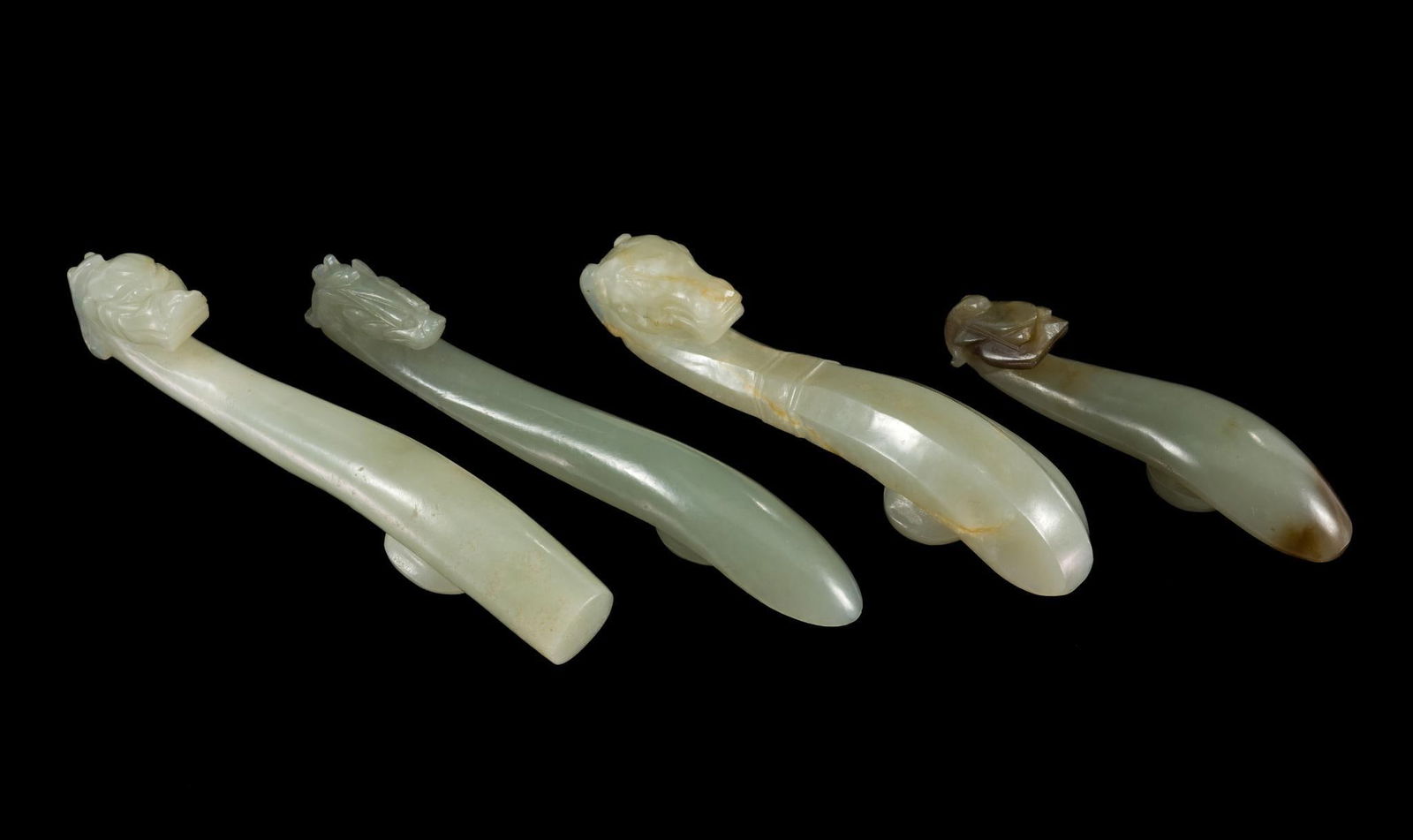 4 Qing Dynasty (1636-1912) Jade Belt Hooks: DESCRIPTION: Four celadon carved belt hooks. All four horse head hooks. Qing dynasty was a Manchu-led dynasty and was the last imperial dynasty in China. PROVENANCE: George Henne November 1866 - June
