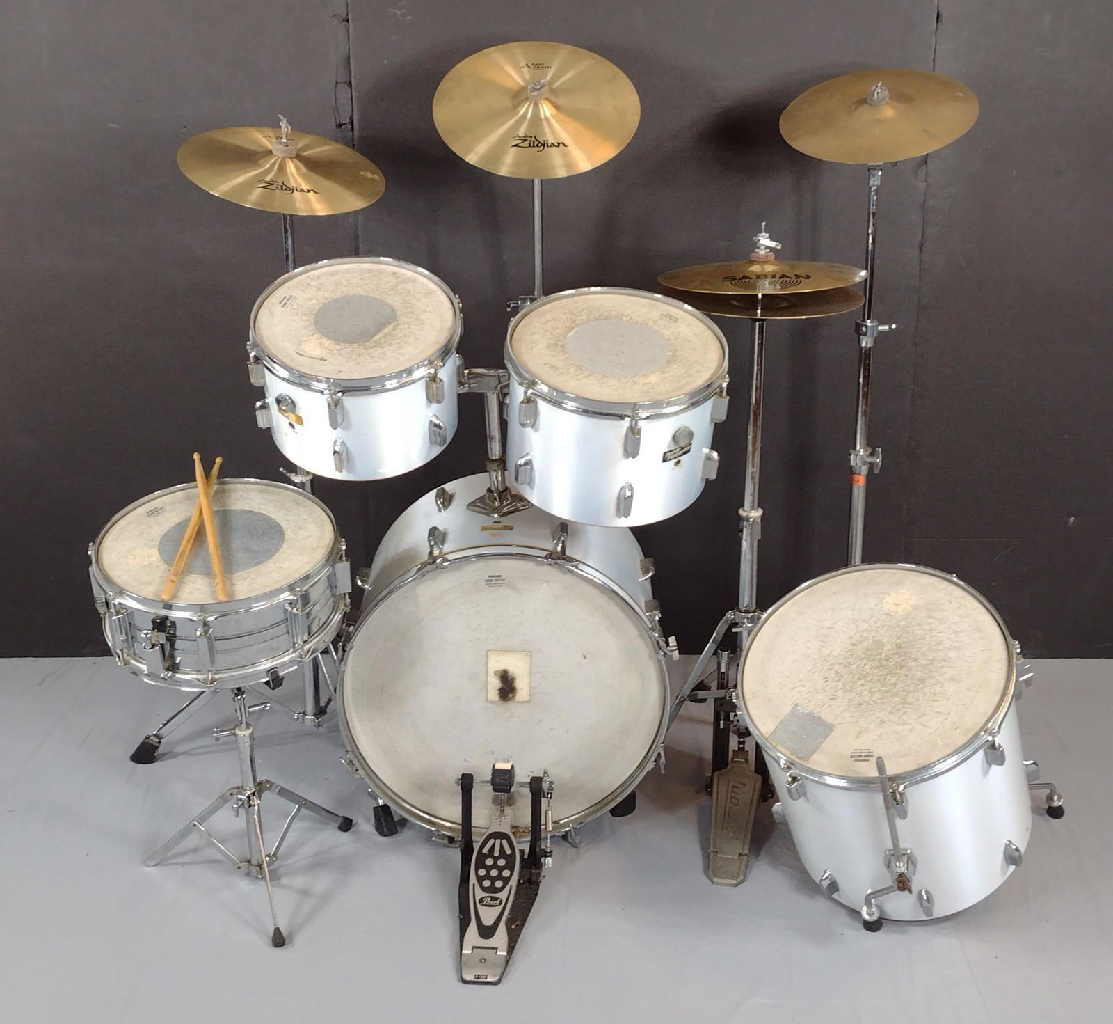 10 Pc Remo/Zildjian Drum Set: Drum set has some wear, has scratches and discoloring. Missing legs for kick drum. One symbol has crack. Stool has tears in seat. MG.