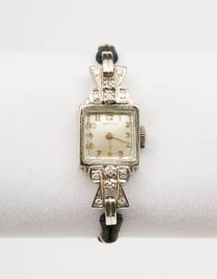 Hamilton Ladies Wrist Watch In 14k Case: Hamilton ladies wrist watch in 14k white gold case with 12 1 point diamonds. Lug to lug 1-1/4". Maximum band length 5". AJ.