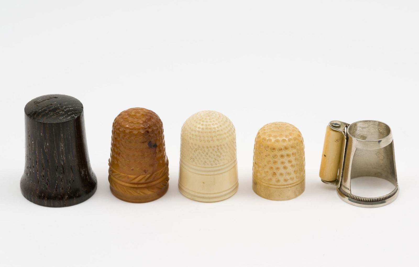 5 Antique Thimbles Incl. Bog Oak & Hem Roller: "Patent 1870" on hem roller thimble. Good condition with minor wear as expected with age and use. AJ.