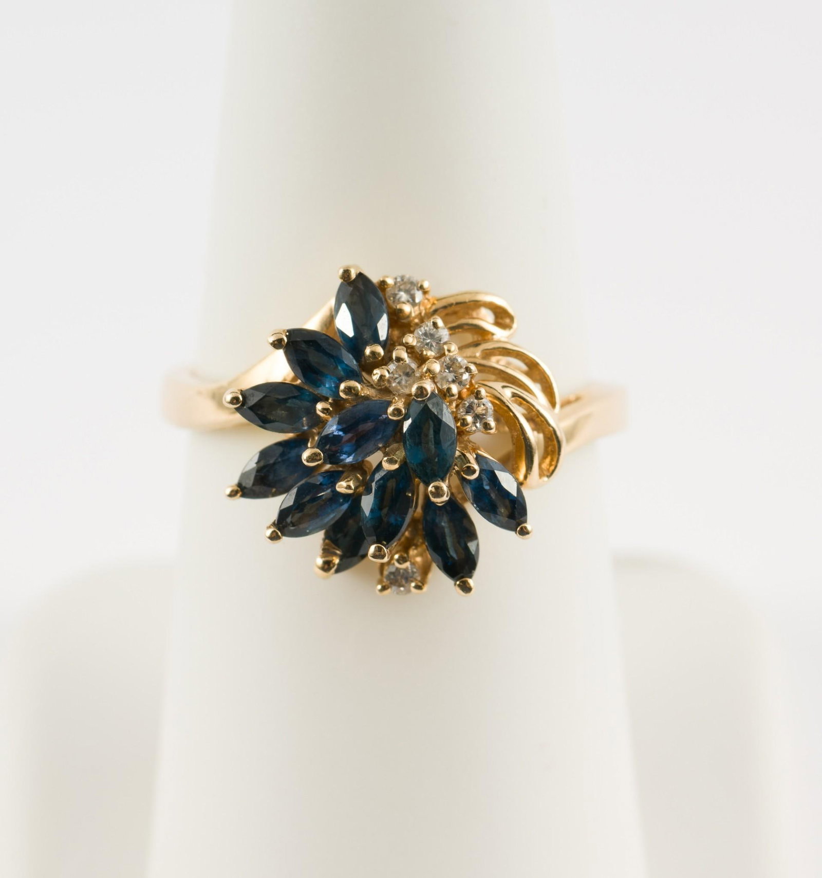 14K Gold Cocktail Ring With Sapphires and Diamonds: 14k gold ring with eleven marquise cut sapphires and six small diamonds. Marked 14k. 3/4" wide. Size 7. 3.8 grams. No condition issues. MEG