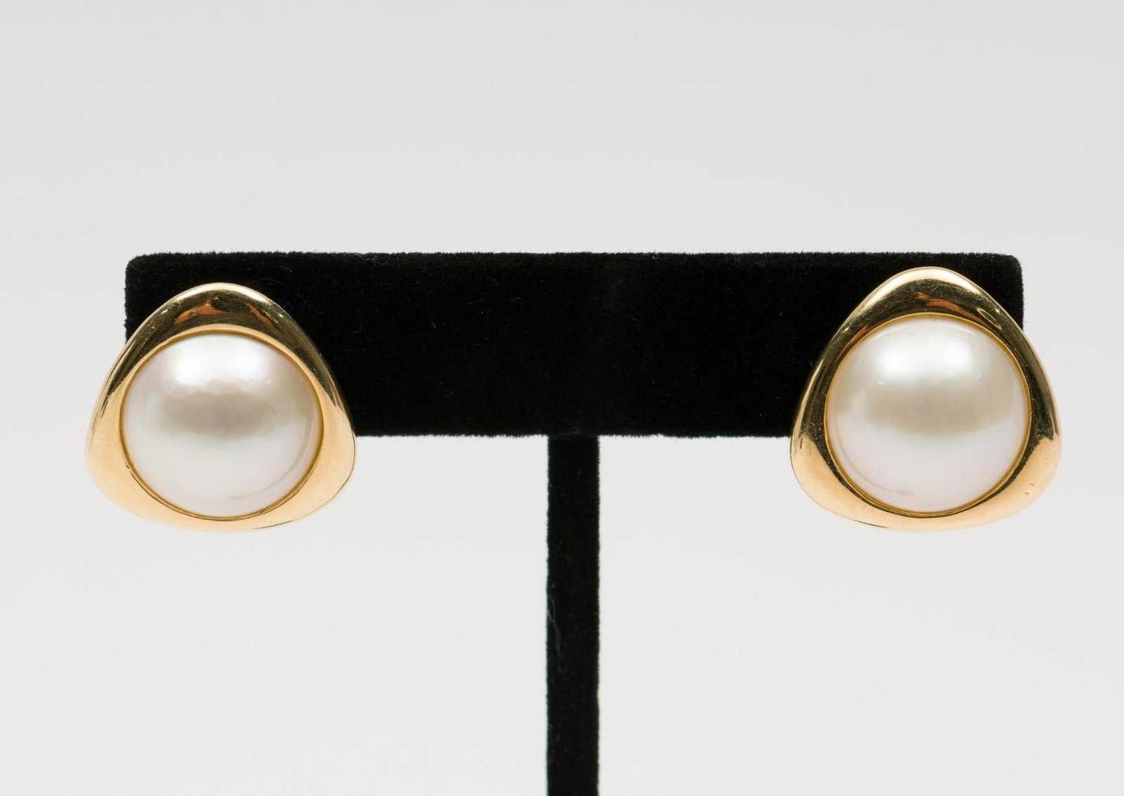 14K Gold & Mabe Pearl Earrings: DESCRIPTION: Marked 14k/585 yellow gold earrings each set with 14mm mabe cultured pearl. Trillion shape with pierced Omega backs. MEASUREMENTS: 9.4 grams. 3/4" wide. CONDITION: Very light wear. EK
