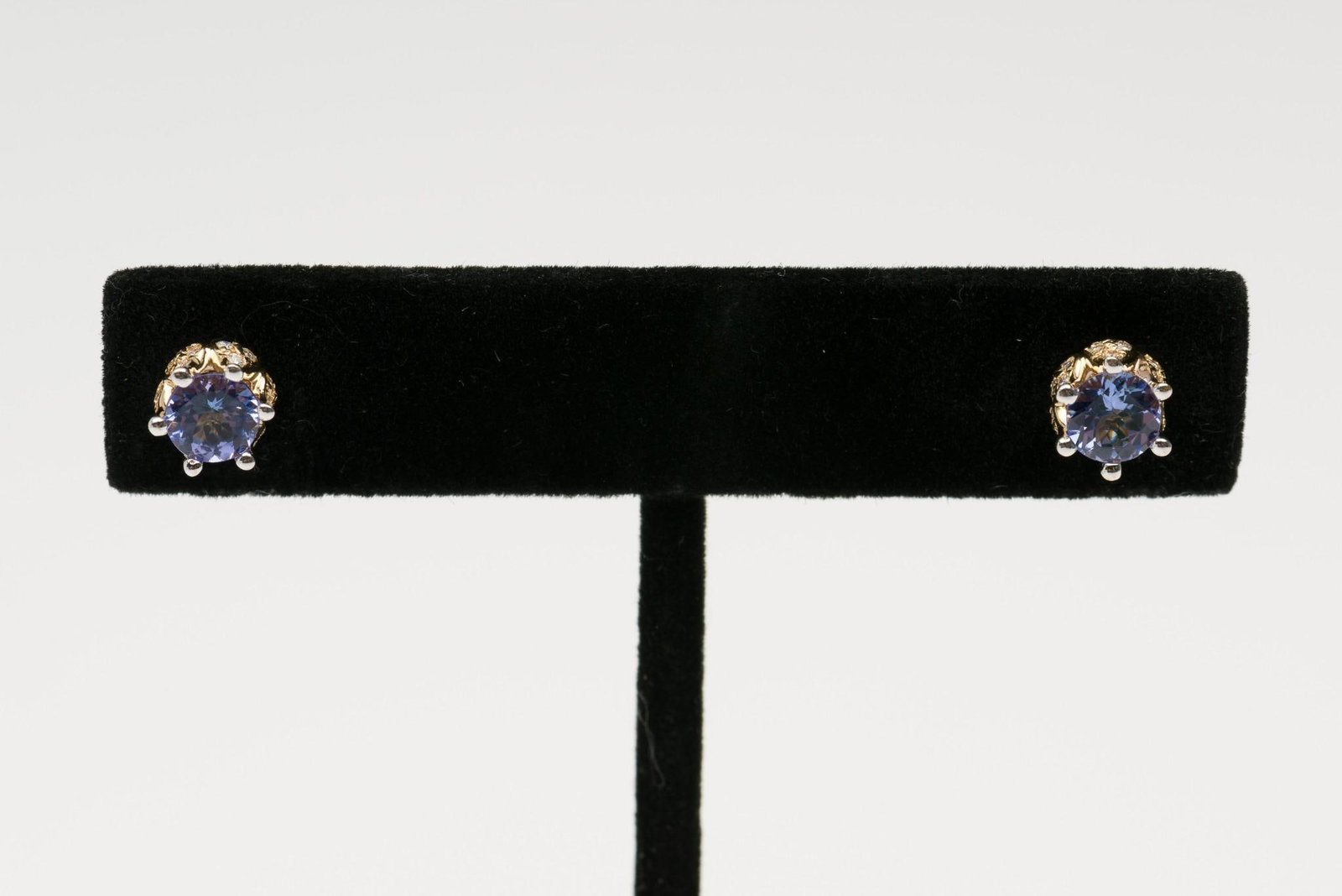 14K Gold, Tanzanite & Diamond "Lotus" Earrings: DESCRIPTION: Marked 14k yellow gold earrings set with center round cut tanzanite. Flower design studs inset with twenty-four round cut diamonds each. MEASUREMENTS: 1.1 dwt. 1/4" wide. Total diamond we