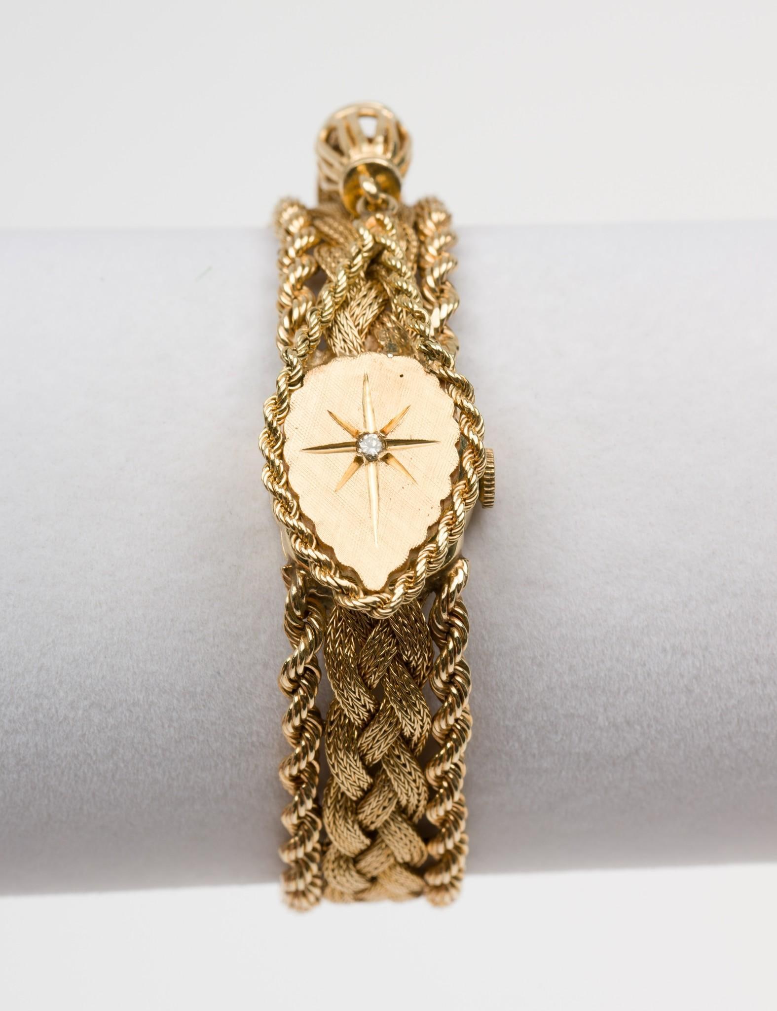 14k Gold Cocktail Watch: DESCRIPTION: 14k gold cocktail watch, ladies hidden dial with spring hinge cover. Gold braided band marked 14k. Back of watch face marked 14k. In original box. Hebe Swiss movement. Manual wind mechani