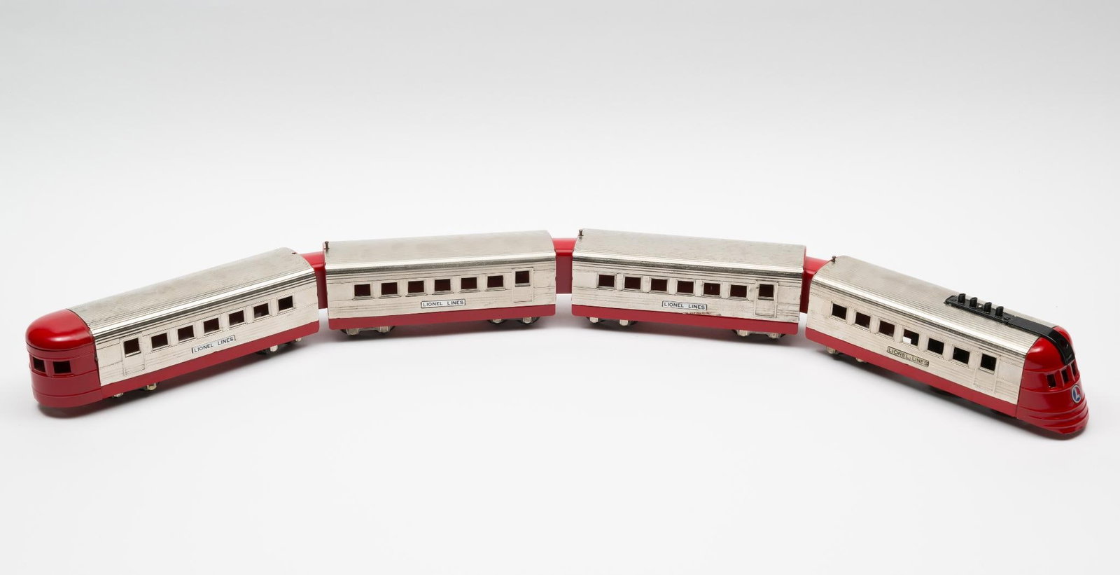 4 Lionel #1700 Streamliner Cars: Lionel #1700 Streamliner set with 4 total cars. Good condition with minor scratching and wear. AJ.