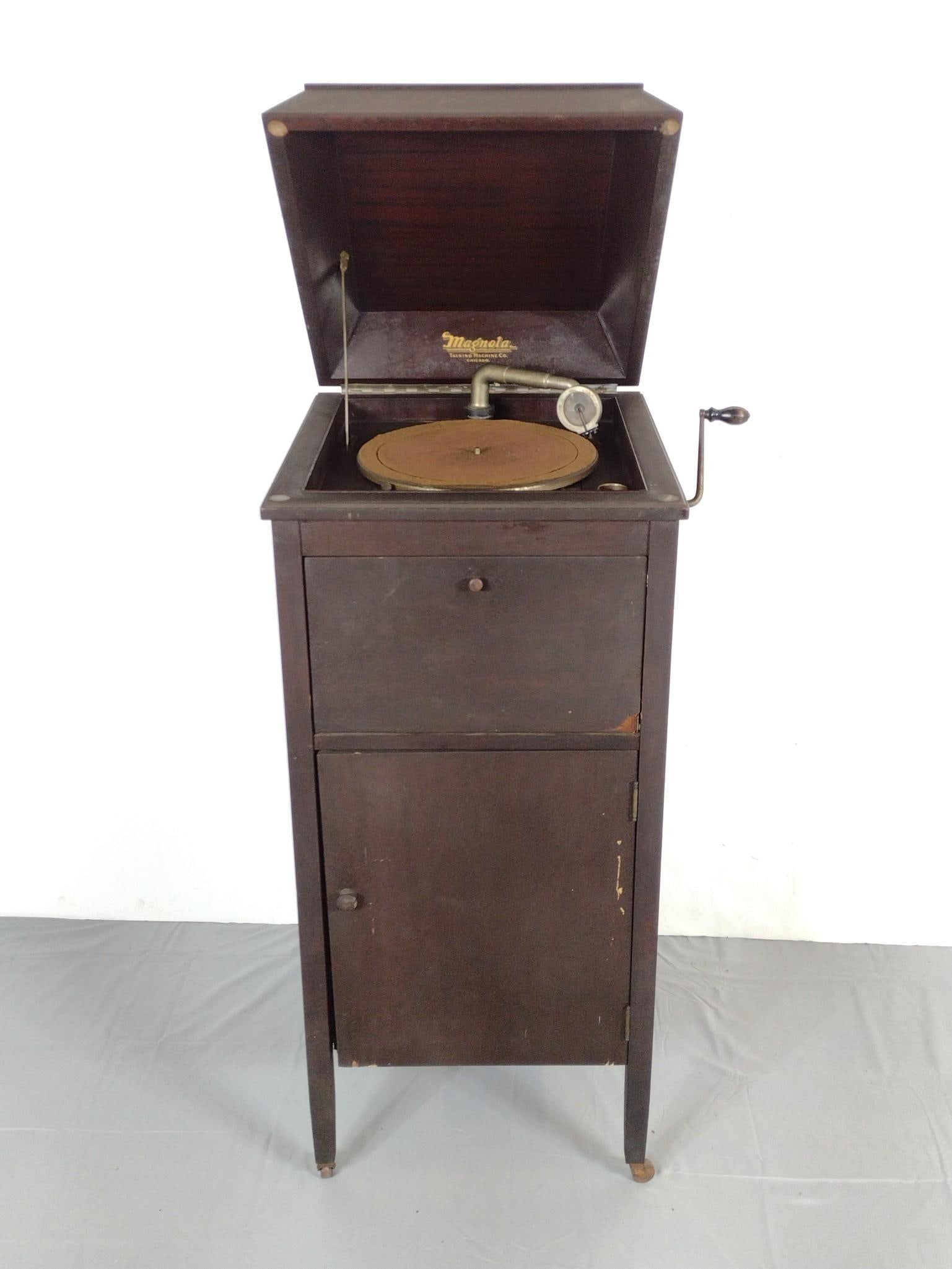 Magnolia Talking Machine: 18-1/2" wide X 20" deep X 43" high. Working. Has some veneer loss on front door. Also has some scratches. MG.