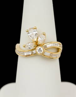 18k Gold & 1 CTW Diamond Cocktail Ring: Marked 18k yellow gold ring set with approximately .10 carat round brilliant cut diamond, approximately .35 carat pear cut diamond, and two .15 carat marquise cut diamonds. Accented by 14 small baguet