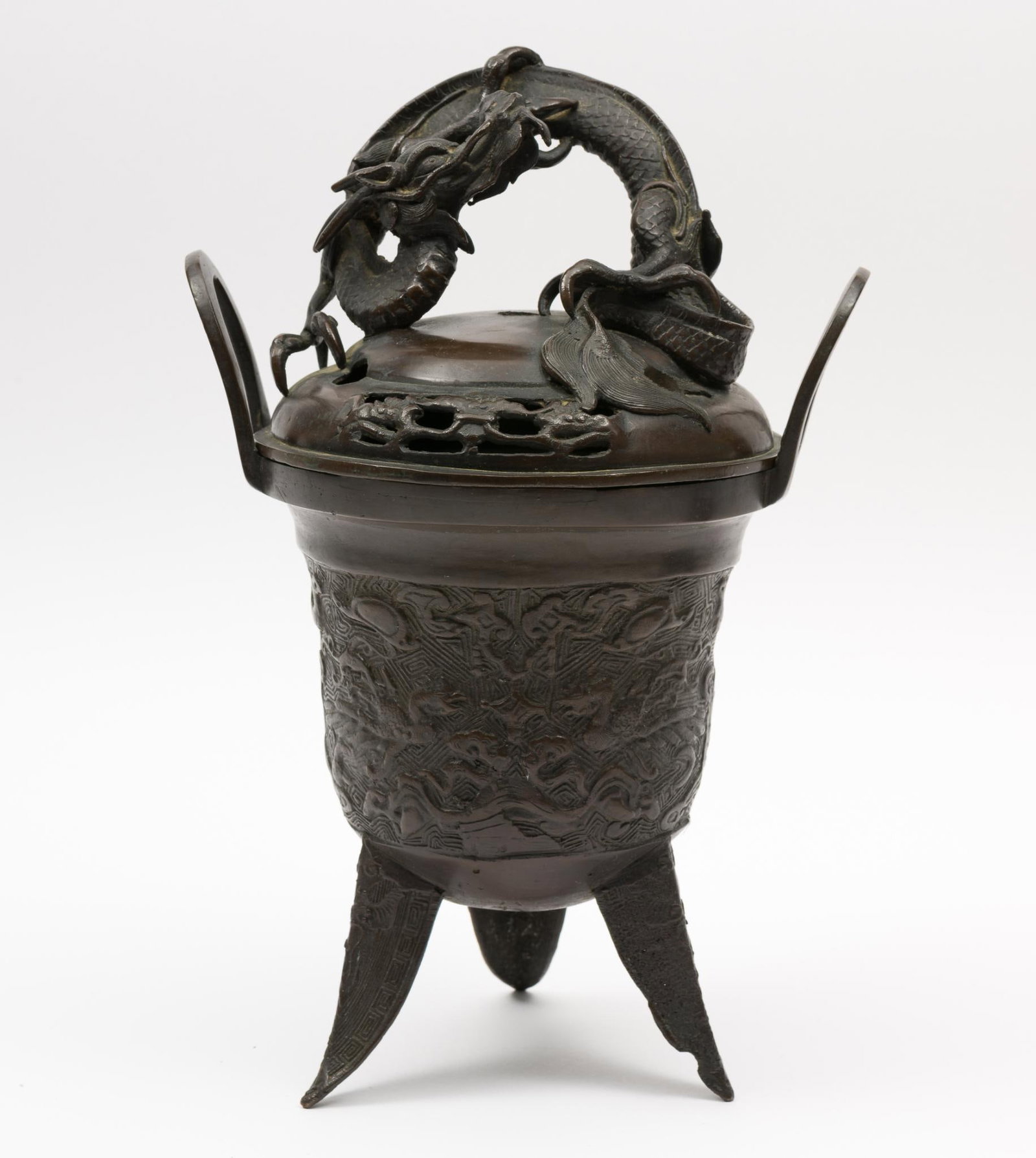 Dragon Lid Brass Incense Burner: Dragon on lid. Sides designed with geometric shapes and dragons. 8" diameter x 13" high. Damage to one leg. MEG