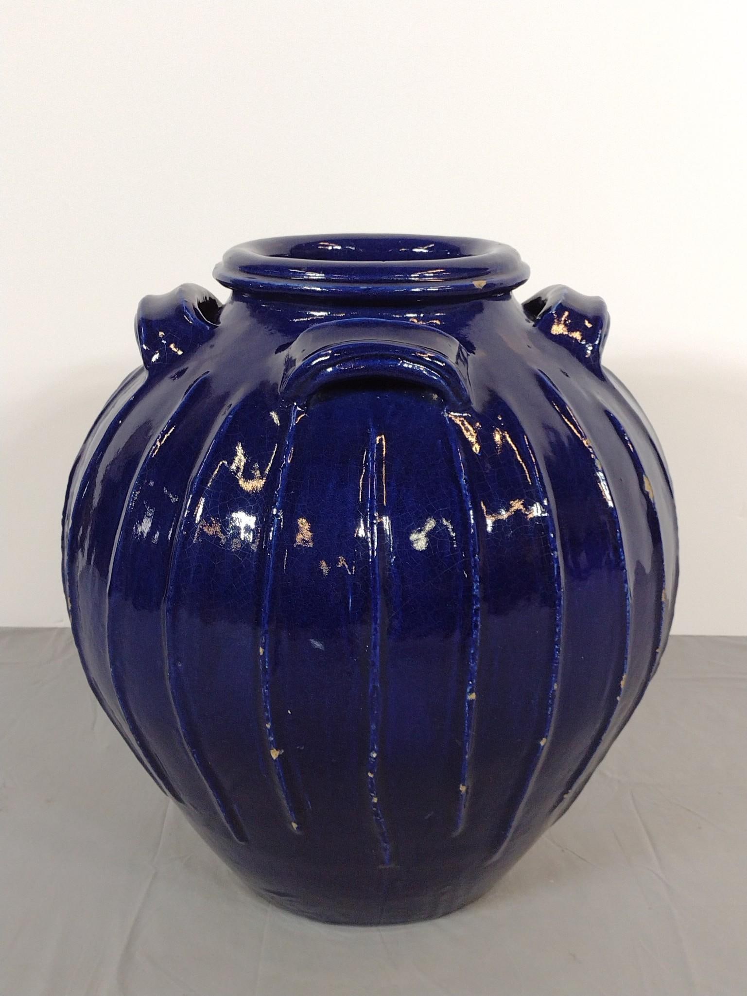 22" Blue Glazed Urn: Reported to be from The Hershey Hotel in Hershey, Pennsylvania. Overall 20" diameter X 22" high. Losses to ribbing around edging. Minor losses to handles and top rim.