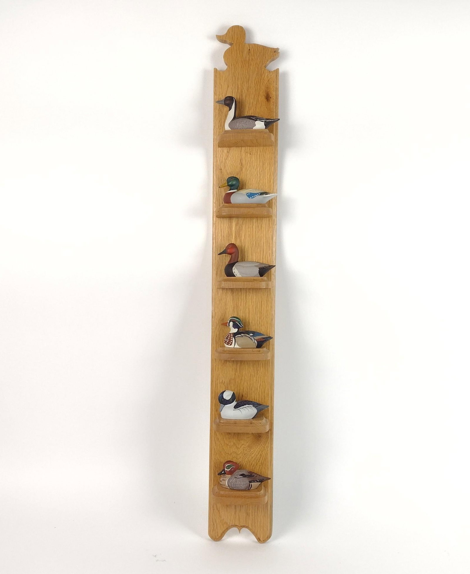 6 Avon Collector Series Duck Decoys with Wall Shelf: Ducks approx. 4" long X 2-1/2" high. Shelf 35" high X 4-1/2" wide. The ducks are made of metal.