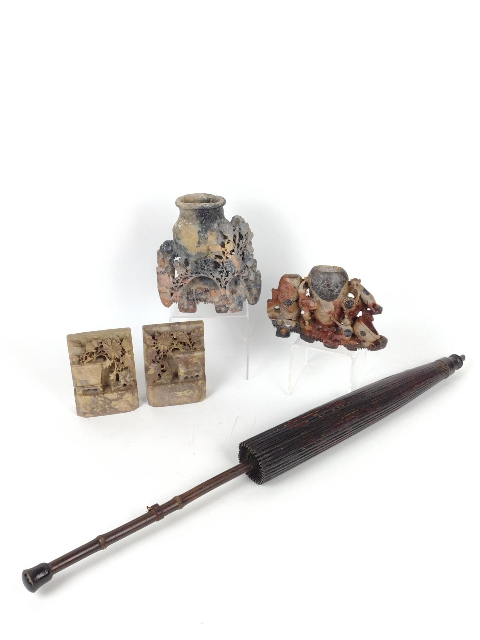 4 Soapstone Carvings and Parasol: Bookends 3-1/4" wide X 1-1/2" deep X 5" high. Large vase 7" wide X 3" deep X 7" high. Has repair at top. Parasol 30" diameter X 30" long. MG.
