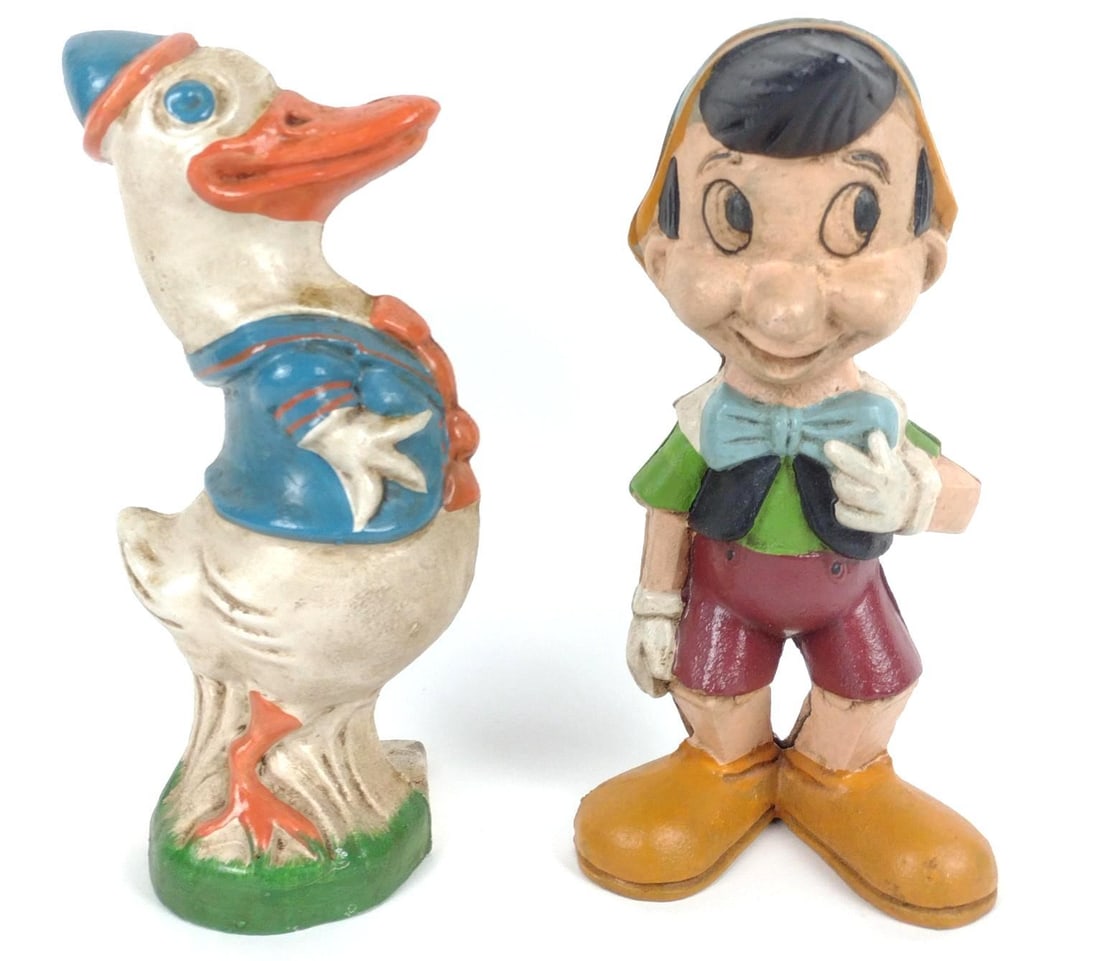 Cast Iron Donald Door Stop and Pinocchio Coin Bank: Each 10" high. Both with some paint losses consistent with age and use.