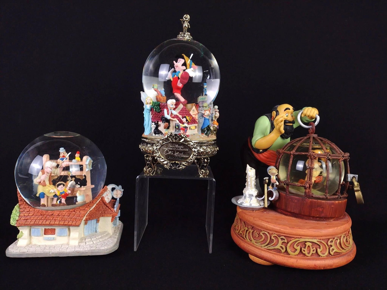 3 Pinocchio Snow Globes: NOT ELIGIBLE FOR IN-HOUSE SHIPPING. Includes 1.) "Beautiful Dreamer" snow globe. Working. 2.) Pinocchio and Geppetto snow globe. 3.) Pinocchio in cage snow globe. Plays little Pinocchio tune. Working.