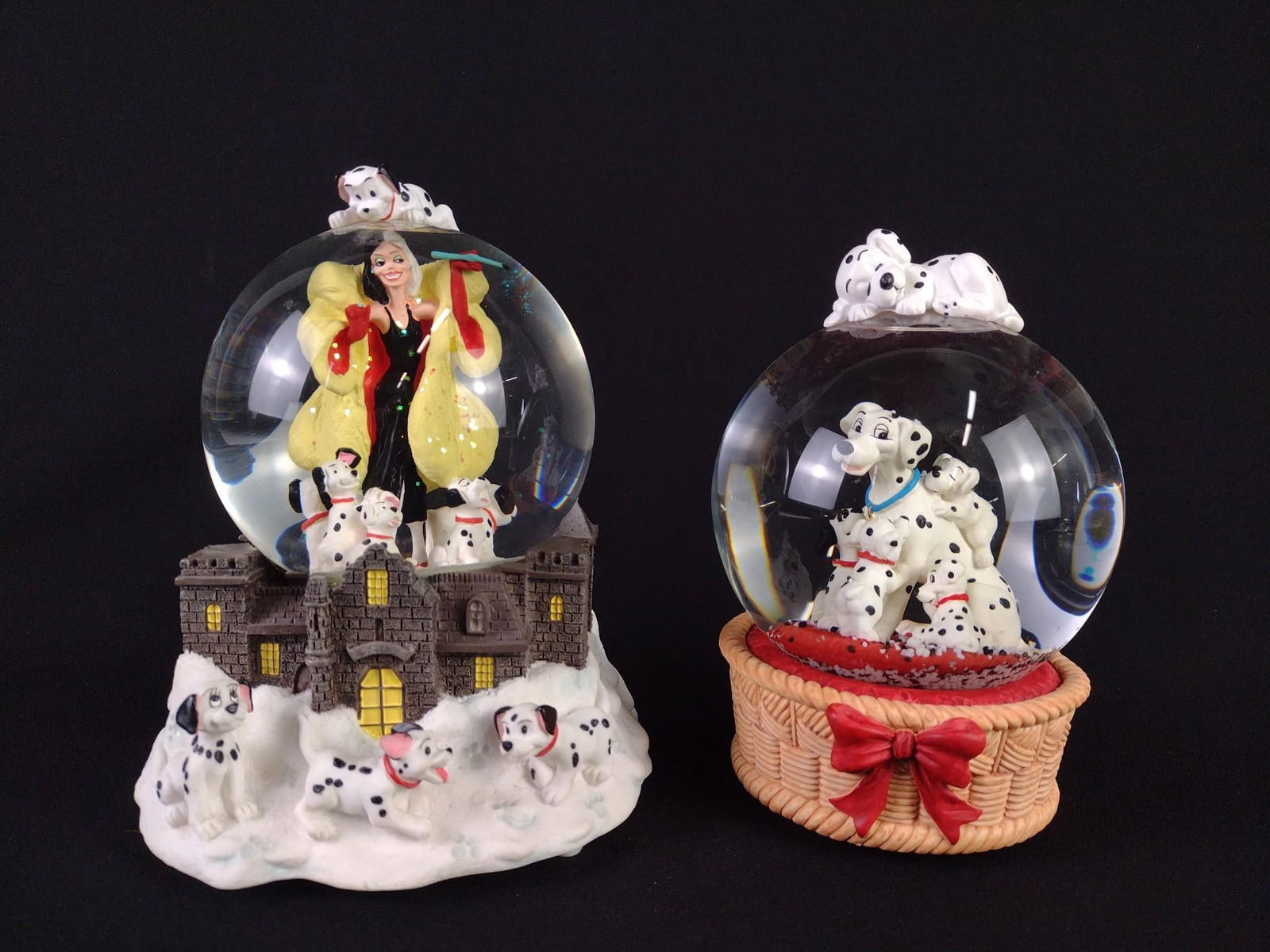 2 - 101 Dalmatian Snow Globes: NOT ELIGIBLE FOR IN-HOUSE SHIPPING. Includes 1.) "Cruella De Vil" snow globe. Working. 2.) Six dog snow globe. Working. 7" to 7-1/4" high.