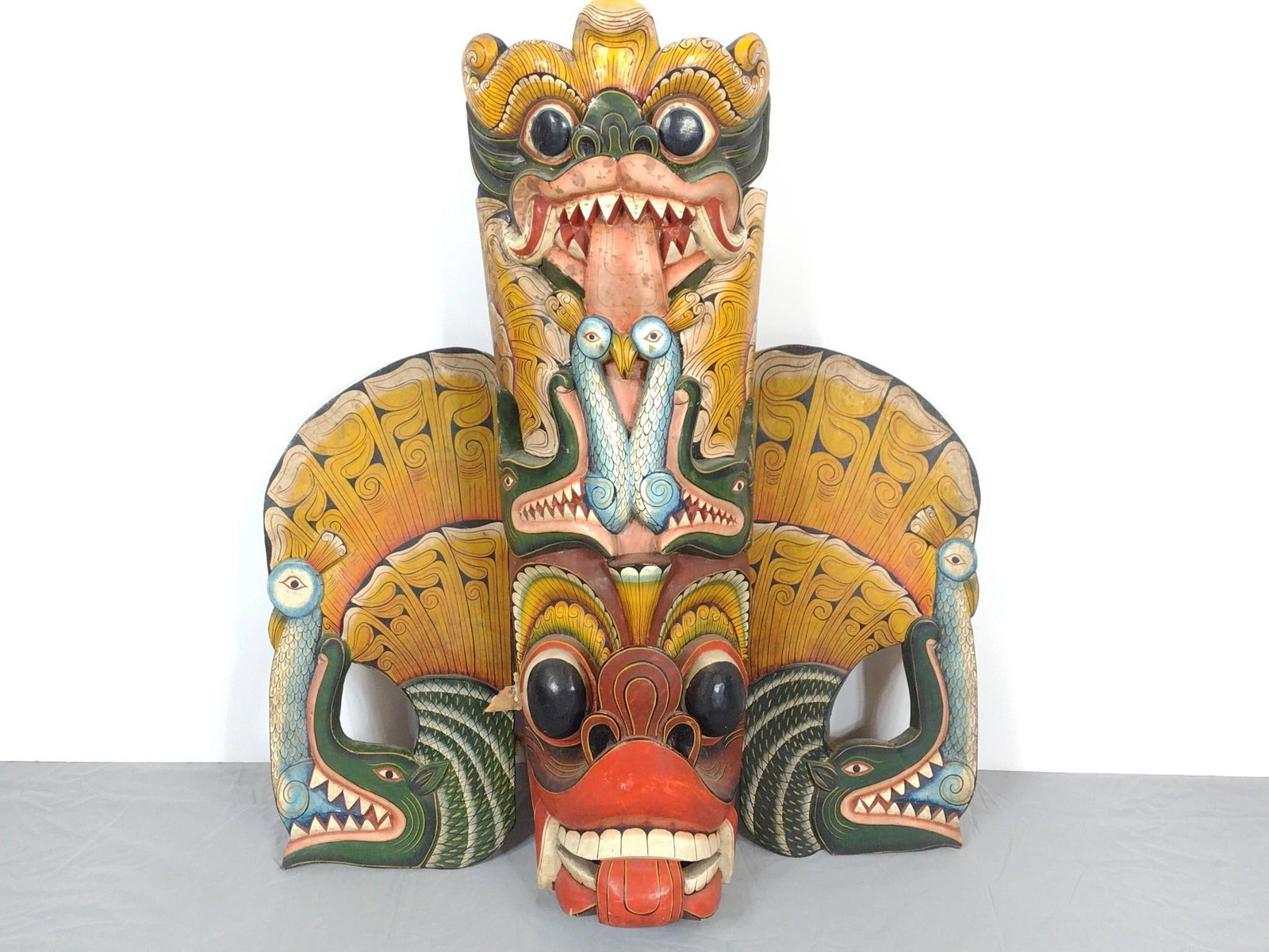 Sri Lankan 3-Piece Carved Wood Mask with Peacock: NOT ELIGIBLE FOR IN-HOUSE SHIPPING. 28" wide X 8" deep X 33-1/2" high. One broken insert. PROVENANCE: From the Estate of James L. Stanfield, Veteran National Geographic photographer (1937-2023). Mr. S