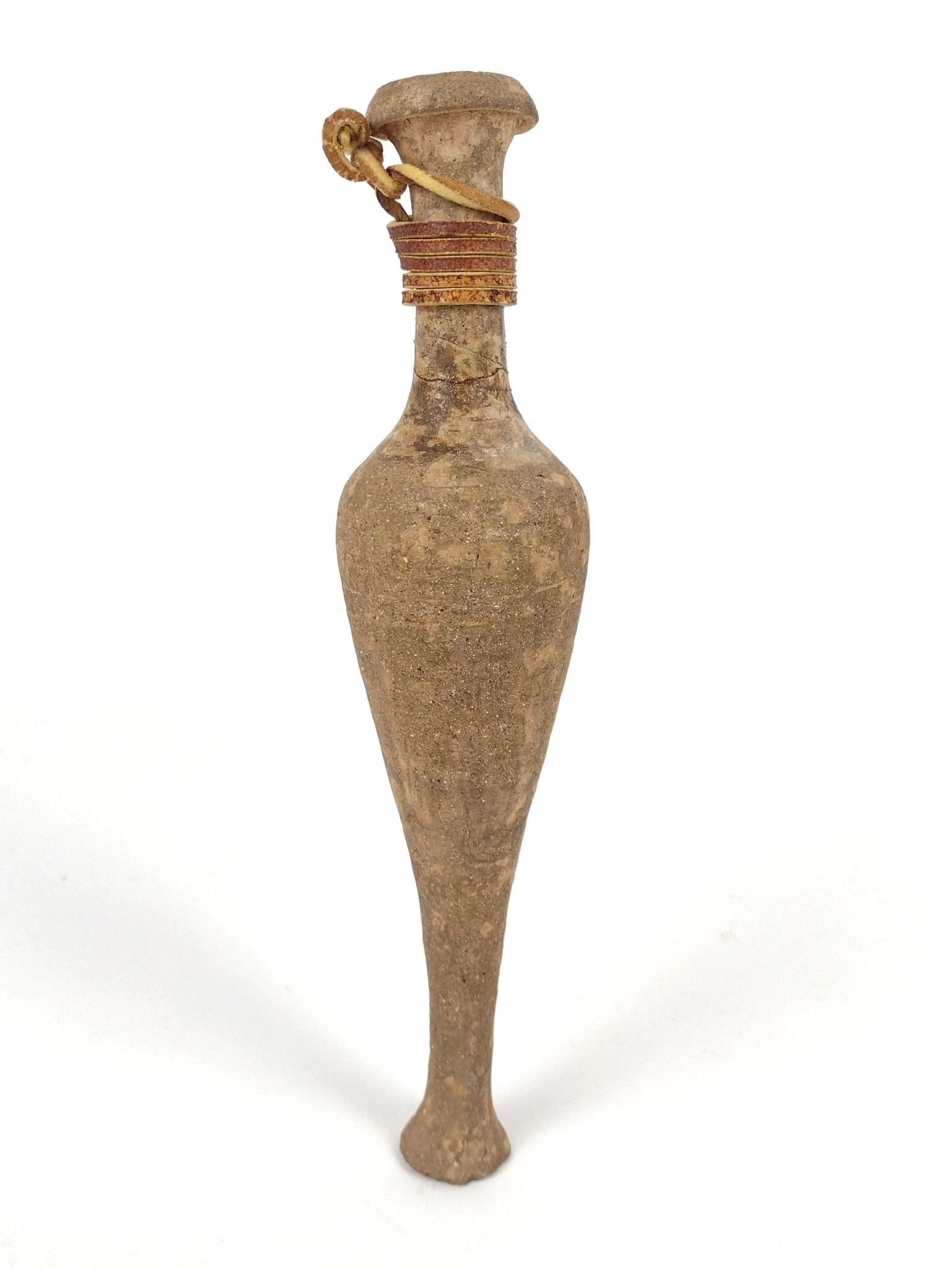 Greek Terracotta Spindle Flask: 2" diameter x 9-1/2" long. Repair at neck. PROVENANCE: From the Estate of James L. Stanfield, Veteran National Geographic photographer (1937-2023). Mr. Stanfield was one of the world's most outstandin