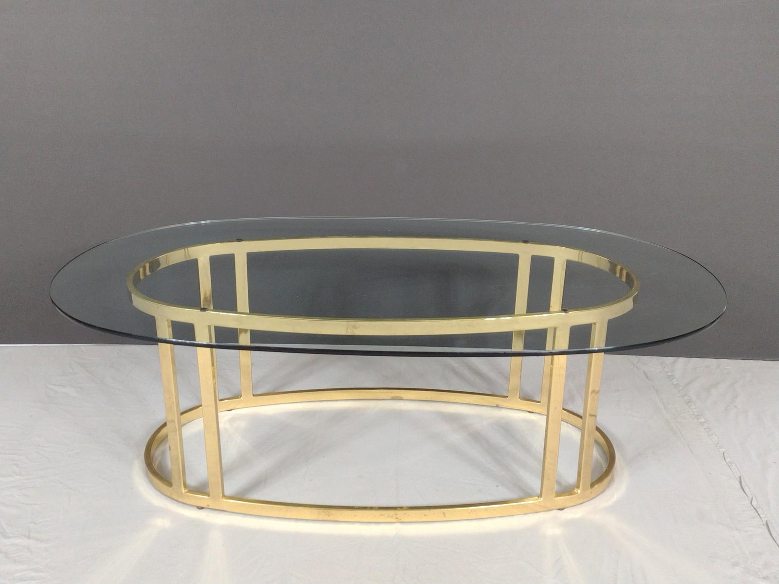 Oval Glass Top Coffee Table: NOT ELIGIBLE FOR IN-HOUSE SHIPPING. 48" wide X 28" deep X 16" high. Metal base has some finish loss.