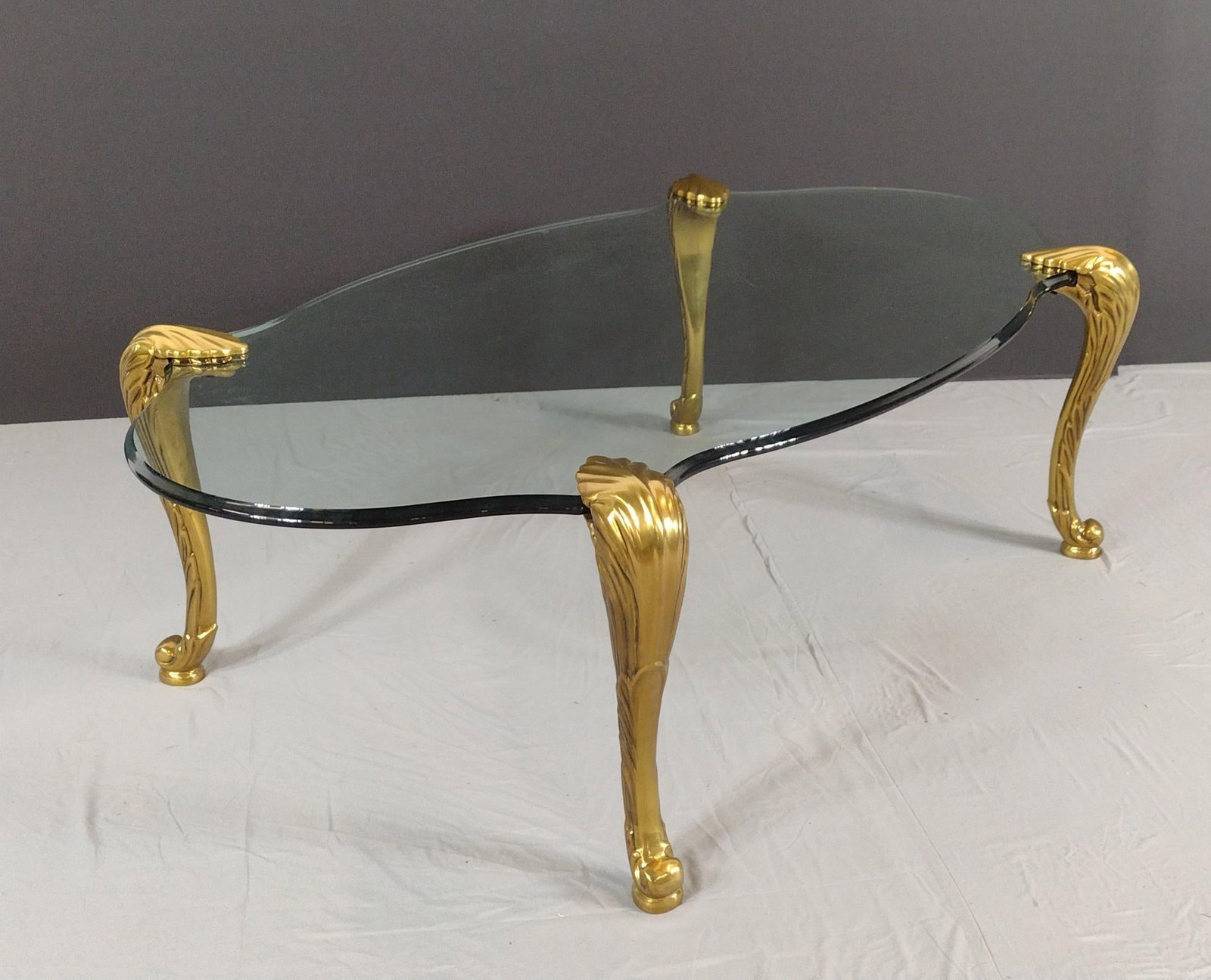 Glass Top Coffee Table With Brass Legs: NOT ELIGIBLE FOR IN-HOUSE SHIPPING. 55" wide X 29-1/2" deep X 16-1/2" high. No manufactures name found.