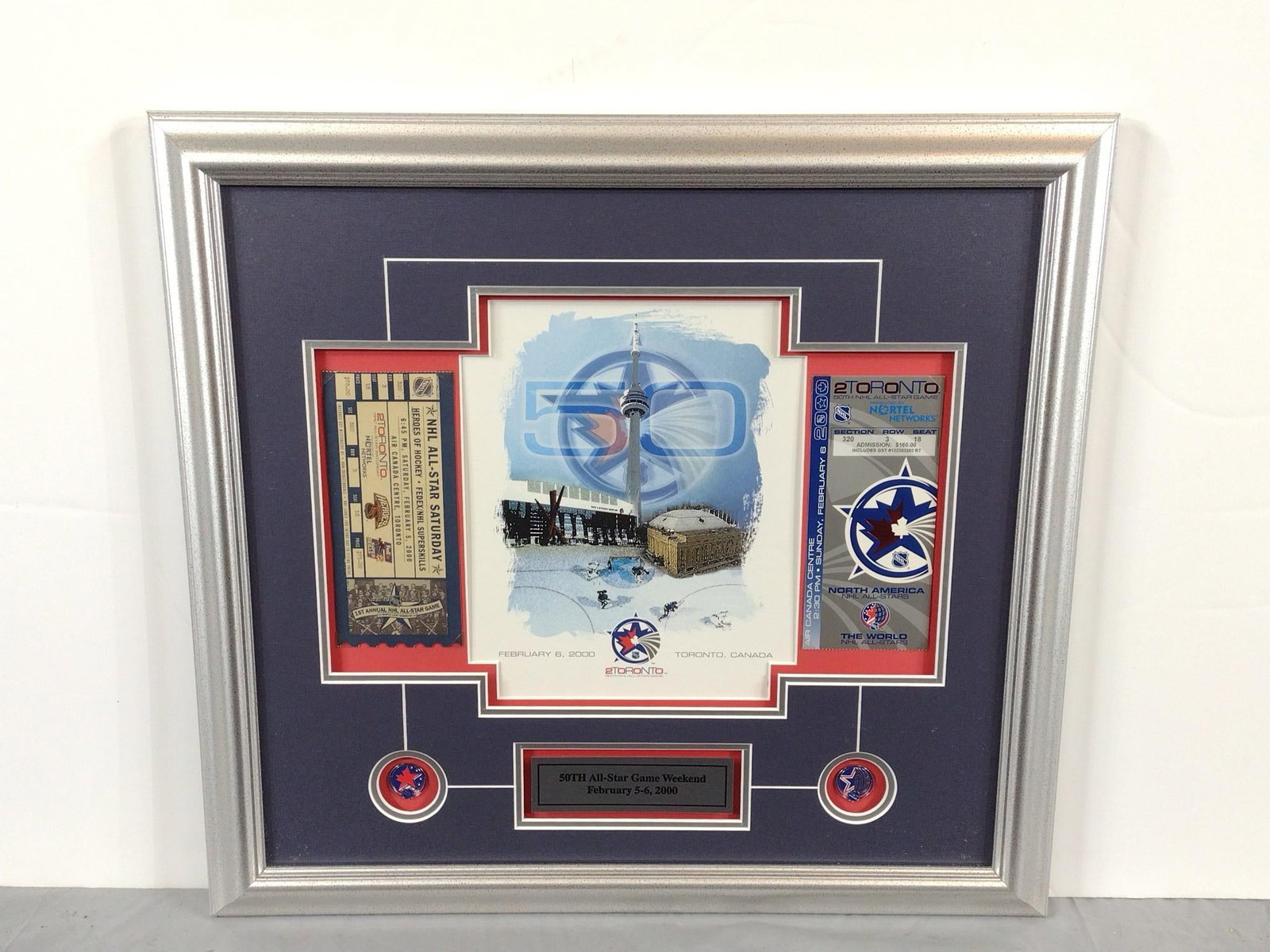 50th All Star Game Weekend February 5-6, 2000 Display: NOT ELIGIBLE FOR IN-HOUSE SHIPPING. Includes tickets and print. Sight: 10" high x 14-1/2" wide. Overall with frame: 19-1/2" high x 21" wide.