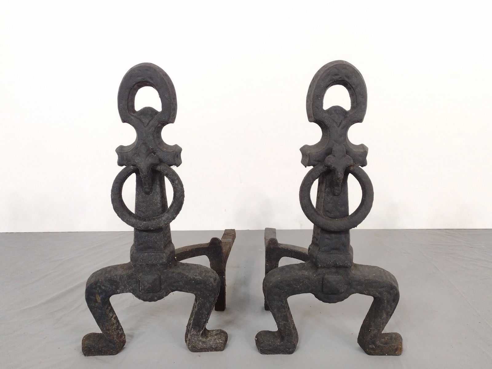 Pair of Cast Iron Andirons: NOT ELIGIBLE FOR IN-HOUSE SHIPPING. Each 9-1/2" wide X 16" deep X 17" high. Has some finish loss.