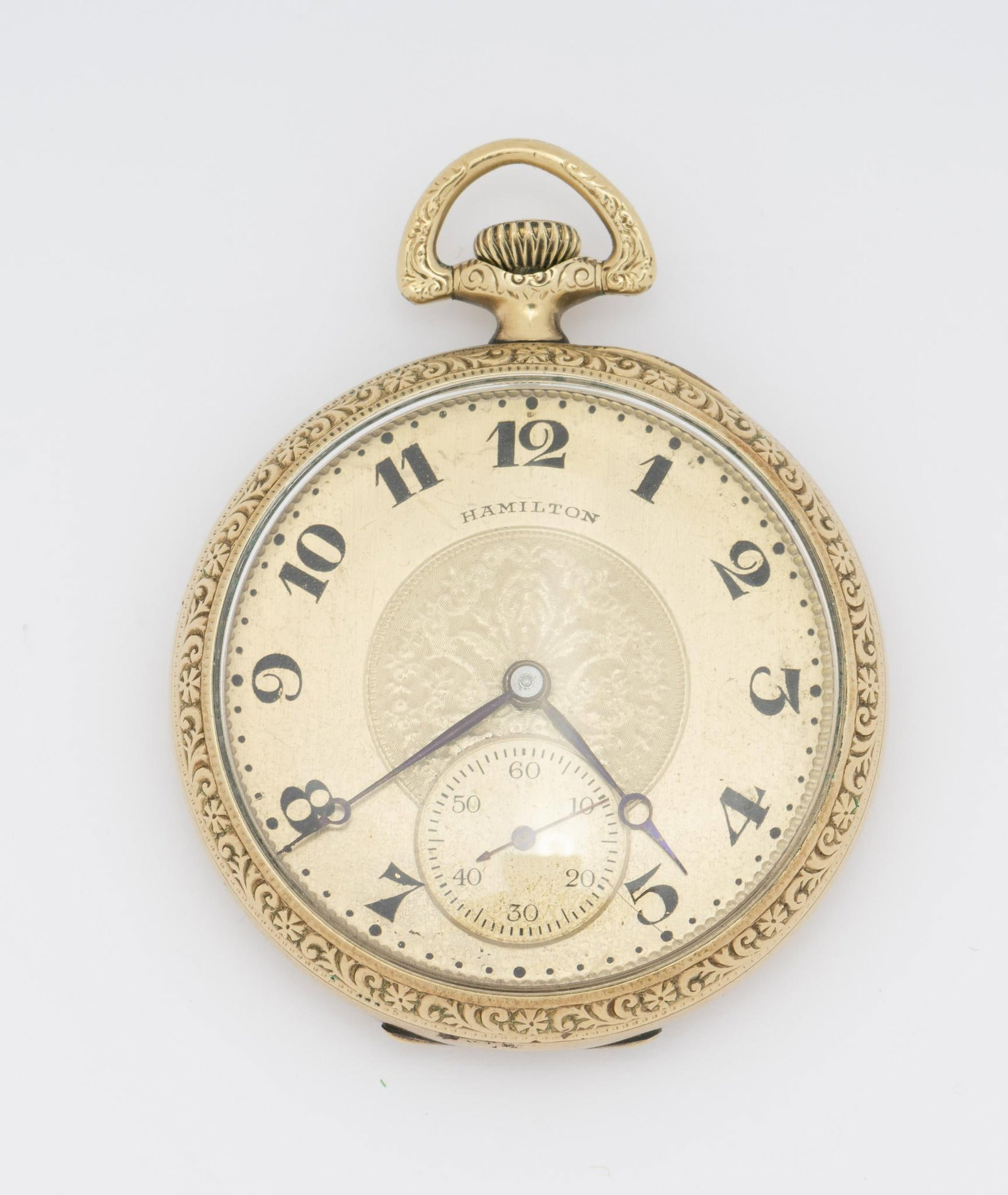 Open Face Hamilton Pocket Watch: Manufactured in approximately 1915. A nicely detailed case in good condition with etched gold dial. Case is gold filled. The watch is a model 910 with 17j movement.