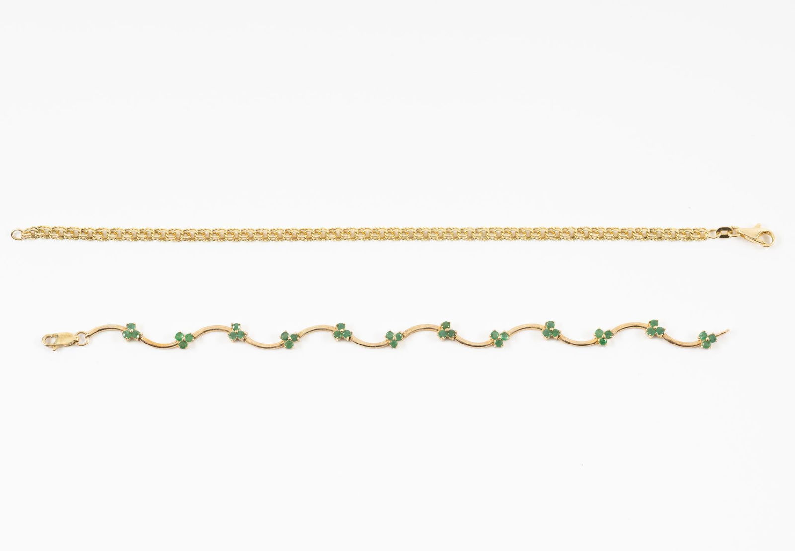 Two 14K Gold Chain Bracelets One With Emeralds: A 7" emerald adorned bracelet with curved bar links and an 8" rope chain bracelet, both with lobster claw closures. Weight of 11.1 grams.