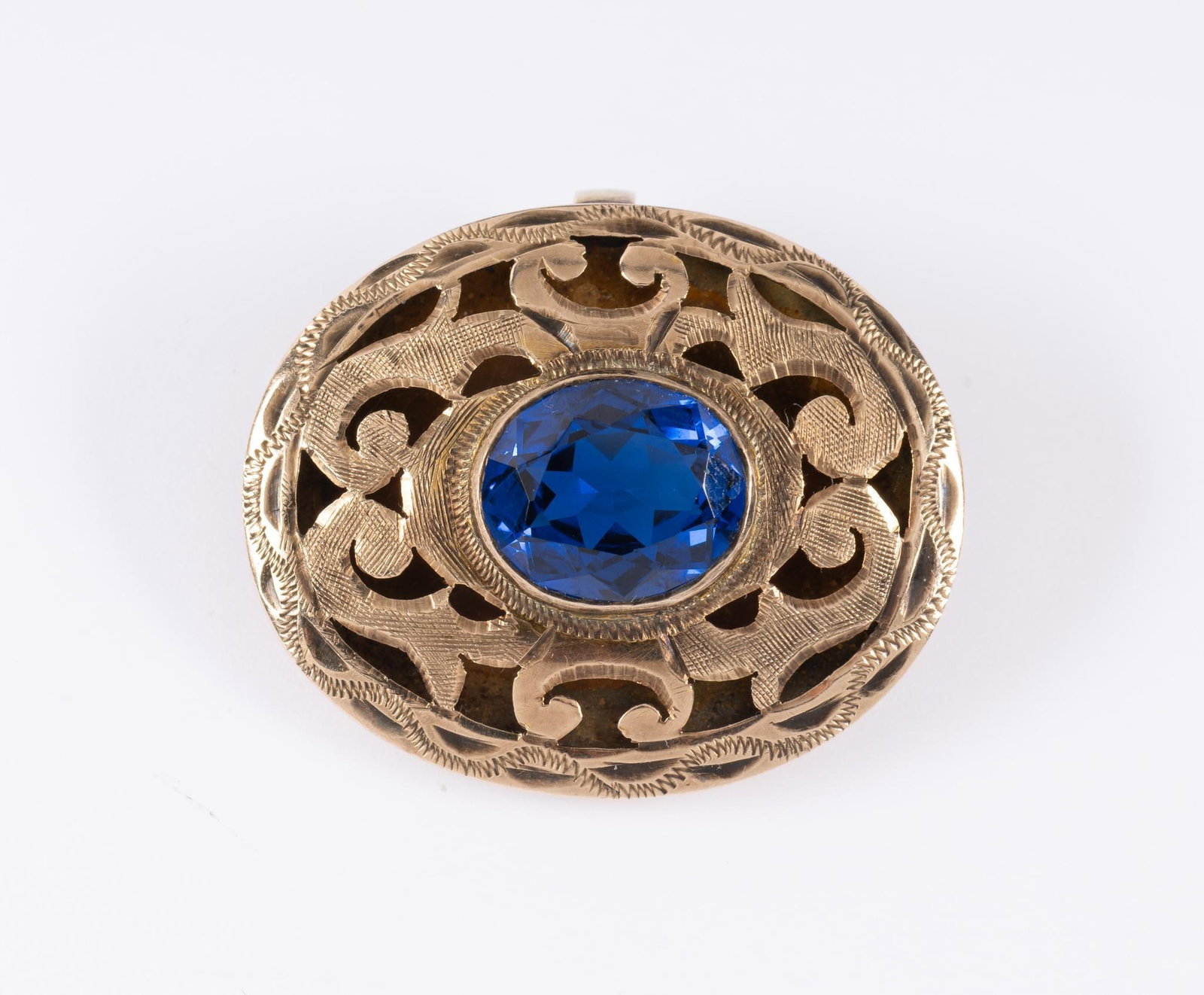 Antique 14K Gold Brooch With Spinel: Vintage brooch with patterned openwork and a central 3.5 carat synthetic spinel. Length 1 1/4" and height 1 1/16". Stamped 14k with weight of 7.1 grams.