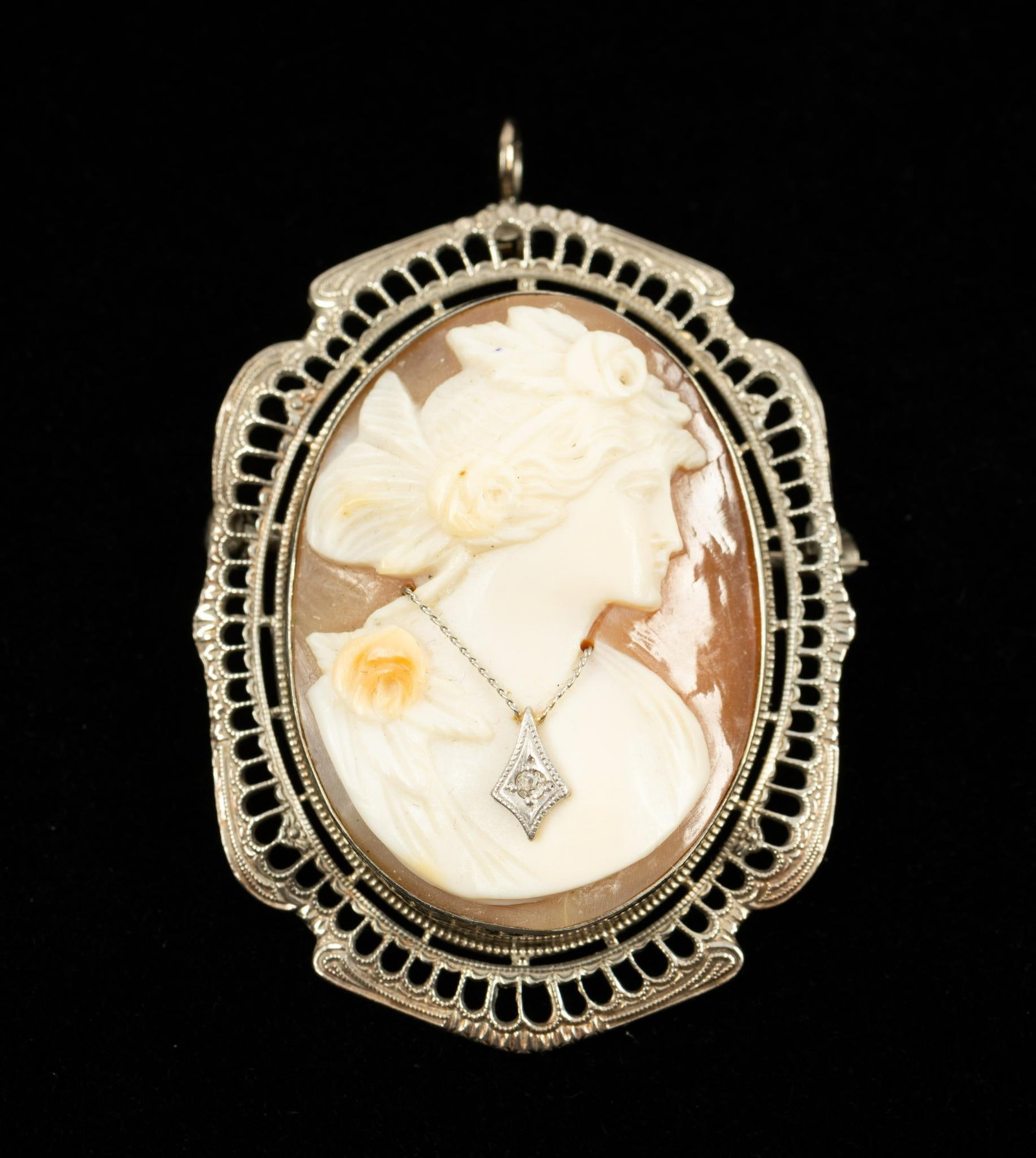10K Gold & Diamond Cameo Pin/Pendant: Marked 10k white gold filigree frame set with carved cameo woman with diamond necklace. 1-1/4" x 1-3/4".