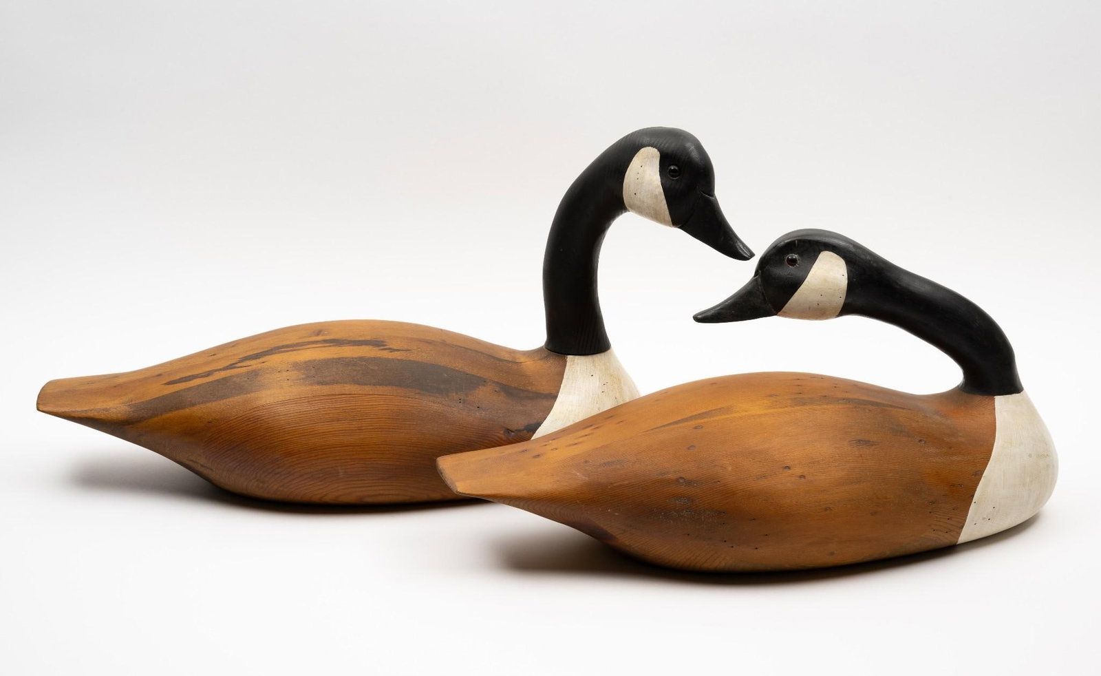 2 French Broad River Decoy Company Decoys: NOT ELIGIBLE FOR IN-HOUSE SHIPPING. Both are Canadian Geese. 10-1/2" to 13-1/4" high x each approximately 22" long. One with detachable neck.