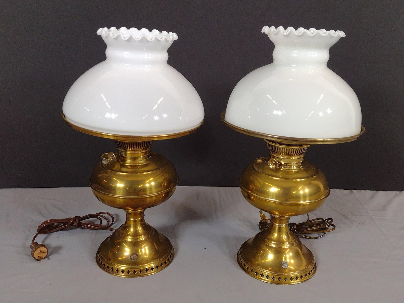 2 Brass Lamps incl Bradley and Hubbard & Rayo: NOT ELIGIBLE FOR IN-HOUSE SHIPPING. Both working. 10" to 10-1/2" diameter x 18-1/4" to 18-1/2" high. Bradley and Hubbard with replacement shade. Shade is a little small for lamp shade frame.