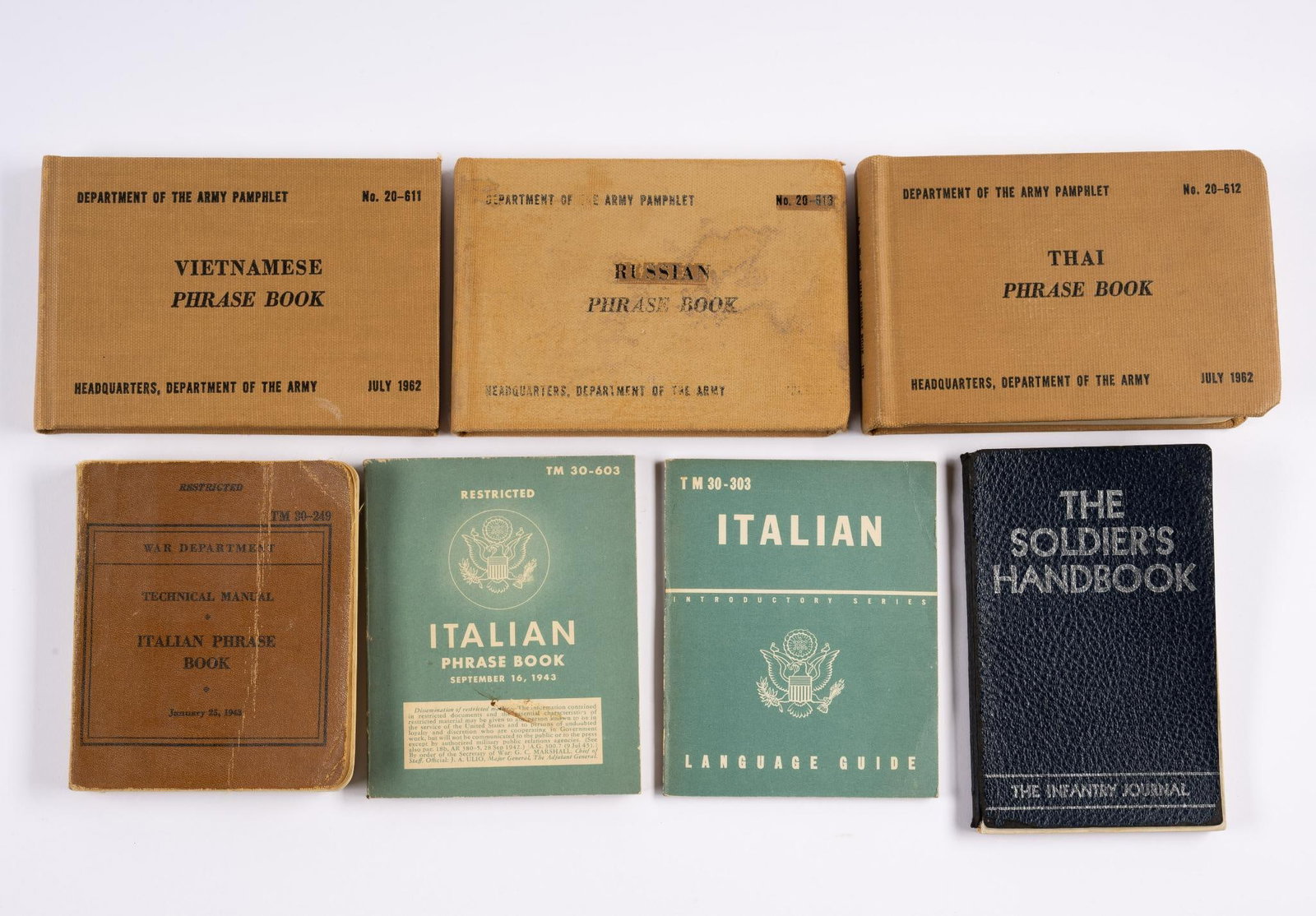 7 Military Phrase & Hand Books: Includes Italian Phrase Books; Soldier's Handbook; Thai Phrase Book; and more. Some damage to spines.