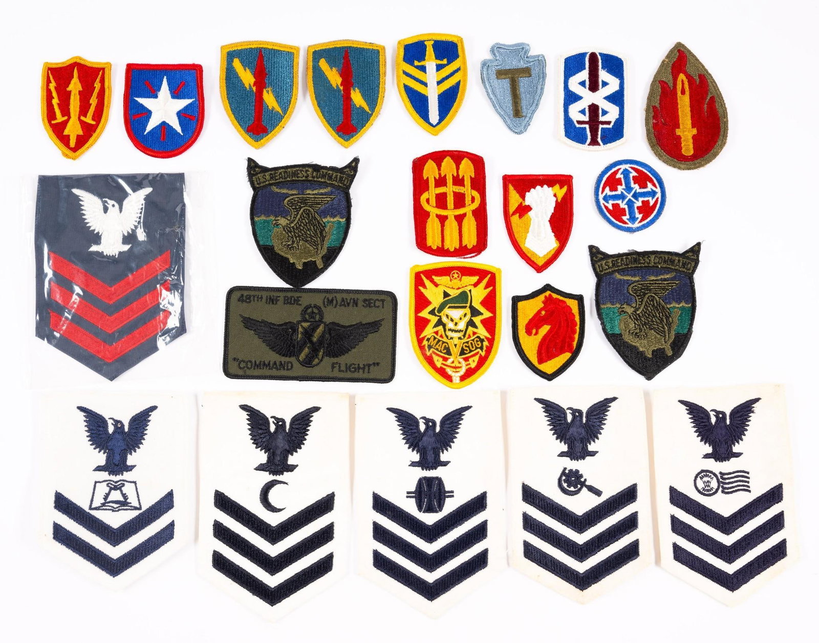22 Military Patches: Includes 18th Medical Brigade; U.S. Readiness Command; 63rd Army Reserve Command; 8th U.S. Army Logistical Command; and more. 2-1/8" to 4" wide x 2-1/8" to 6-1/8" long. Some staining.