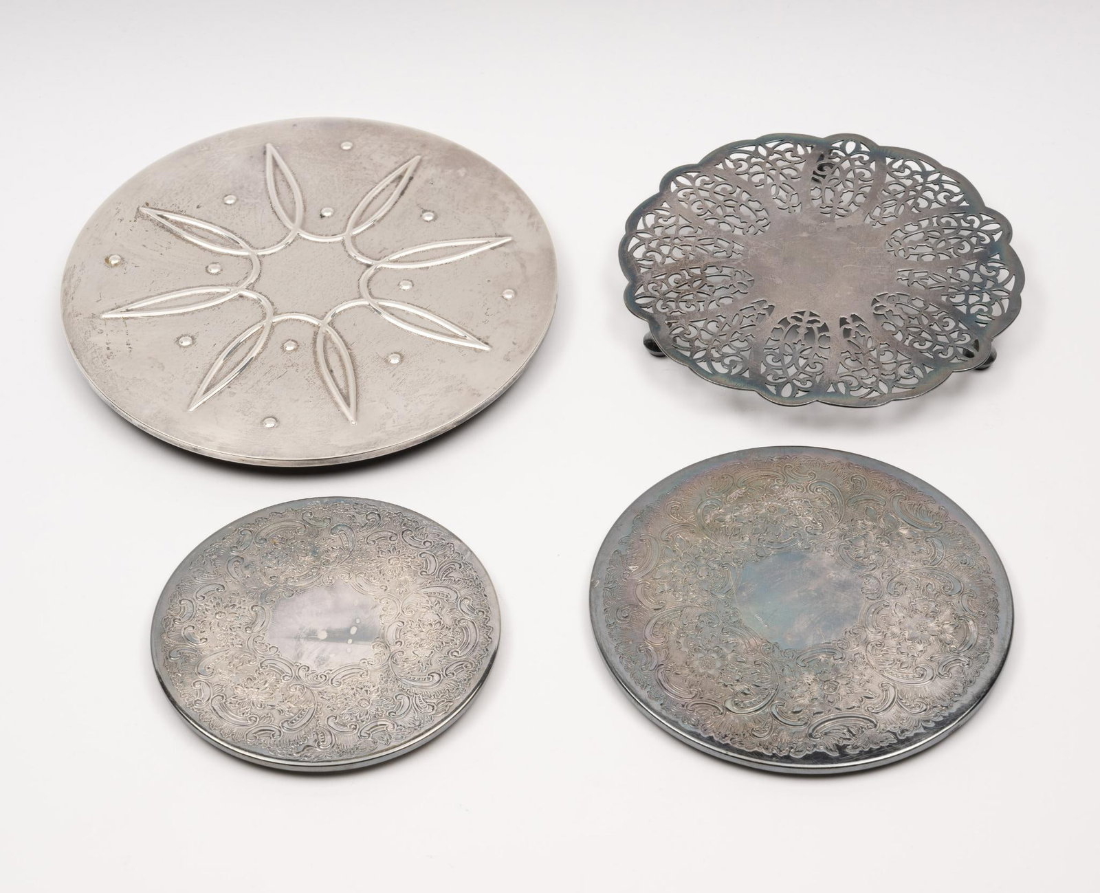 4 Coasters: 3 silverplate and 1 sterling silver. 5-1/8" to 8-1/8" diameter x 1/4" to 1/2" high.