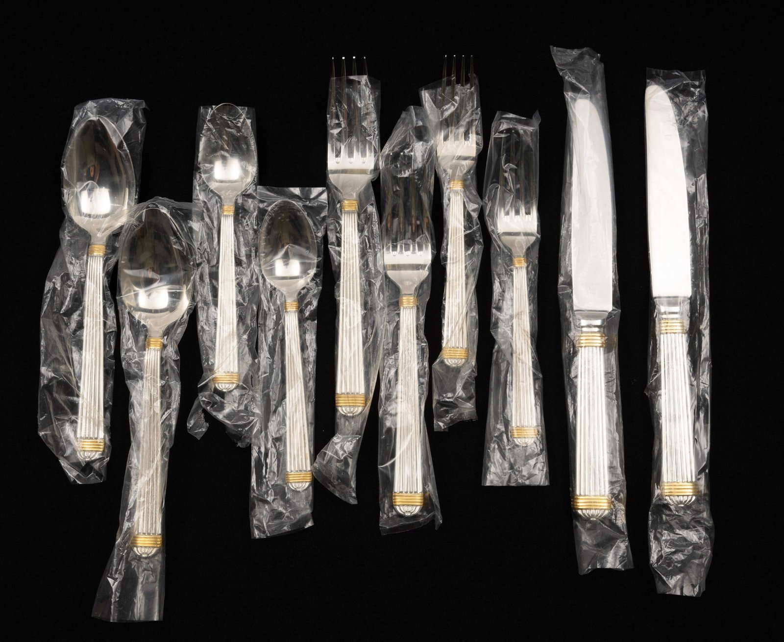 Christian Dior Gaudron Stainless Steel Flatware Spares: New in original bags. (2) dinner knives, (2) dinner forks, (2) salad forks, (2) soup spoons, (2) tea spoons. Dior Gaudron in stainless with gold accents.