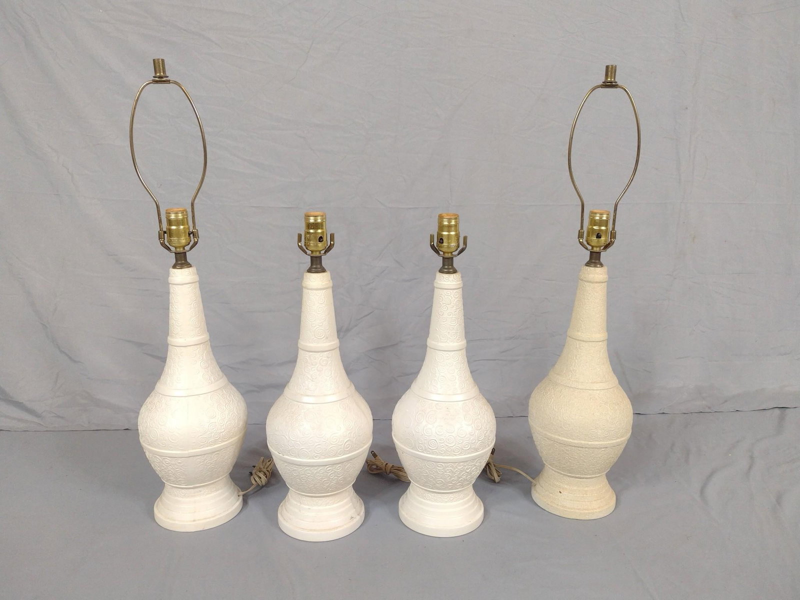 4 Ceramic Table Lamps: NOT ELIGIBLE FOR IN-HOUSE SHIPPING. Some chips to interior bottom rims. Two missing harp. 20" to 28-1/2" high. 7" wide.