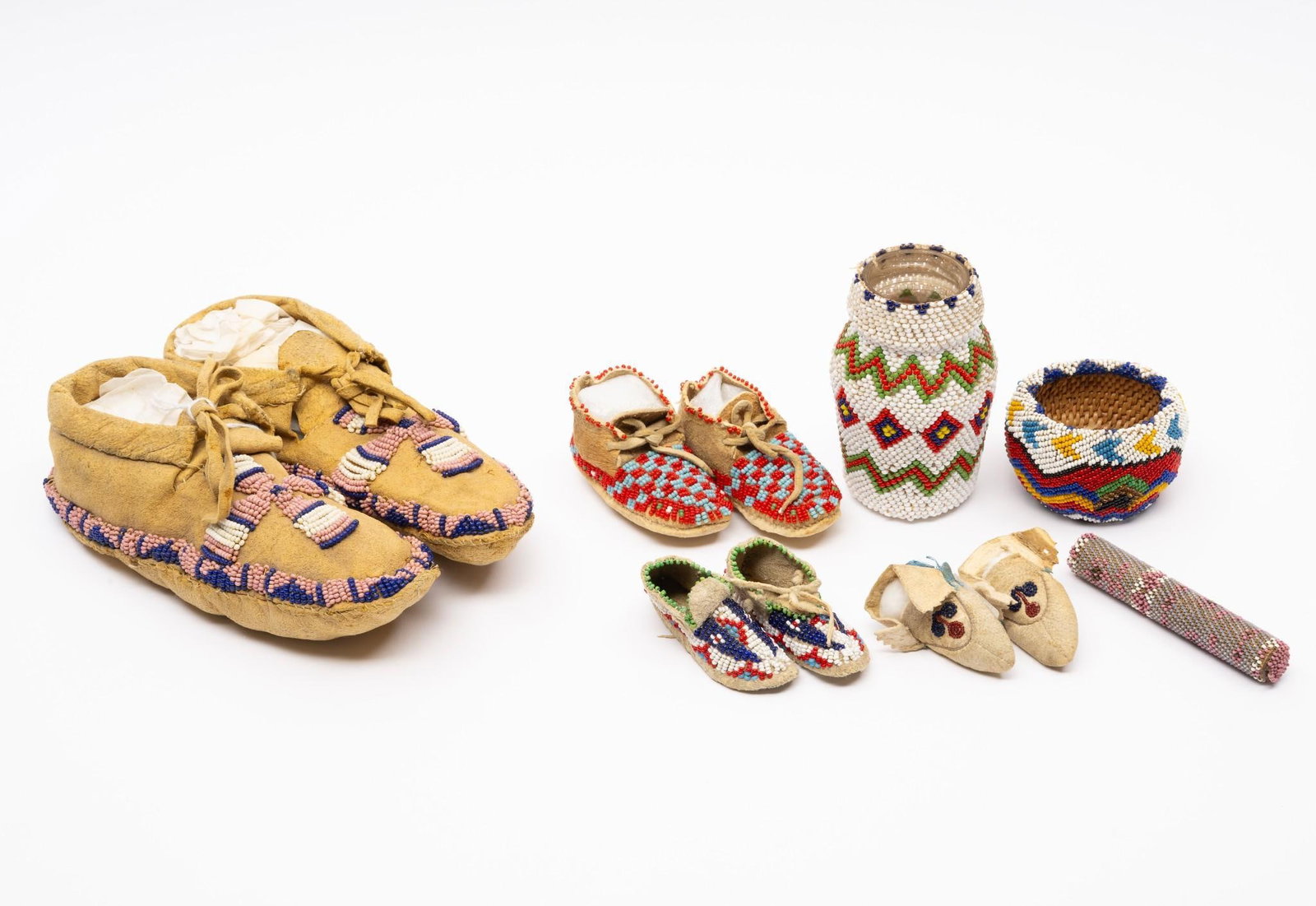 4 Pairs Beaded Children's Moccasins and Others: A group of various tribal beaded objects including four pairs of children's moccasins probably mid 20th century. Two beaded containers probably Mexican, second half of the 20th century and a very fine