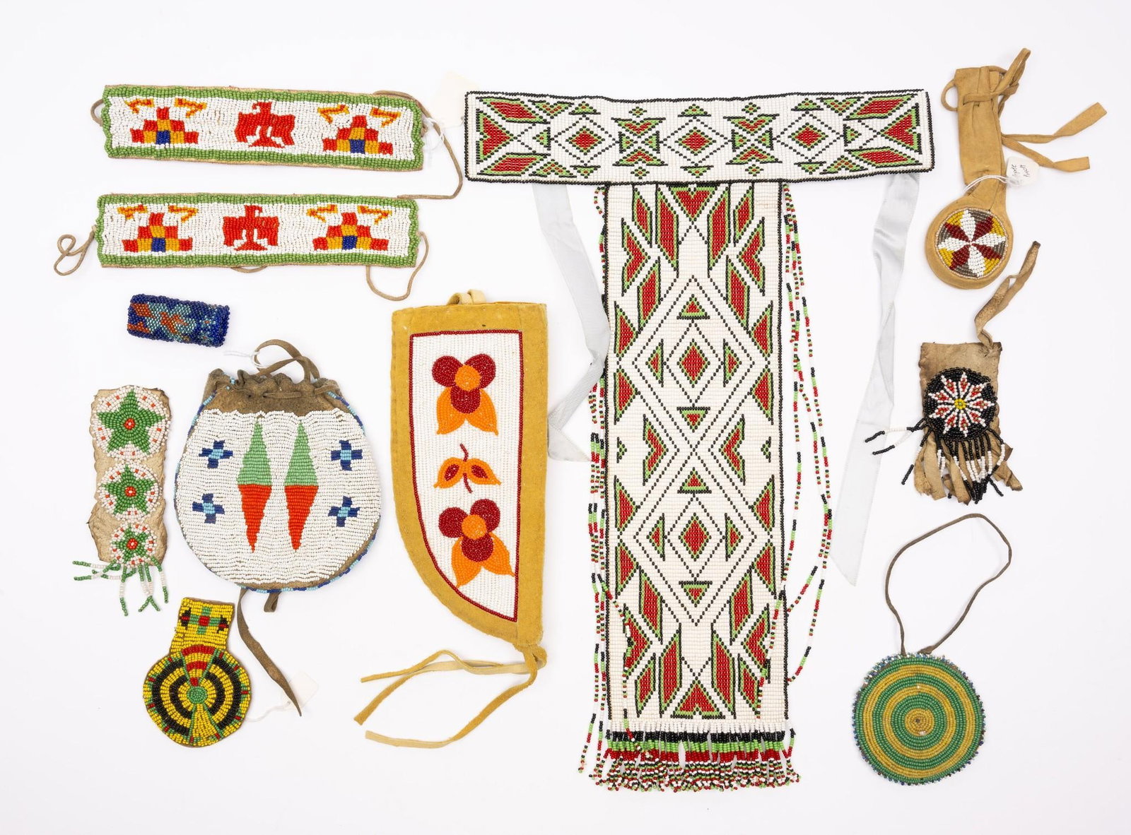11 Various Pieces of Tribal Beadwork: A group of 11 beaded tribal items mostly second half of the 20th century including pow wow armbands, neck tie, watch fob, etc. Measurements: 2-1/2" to 17-1/2" long Condition: Overall good.