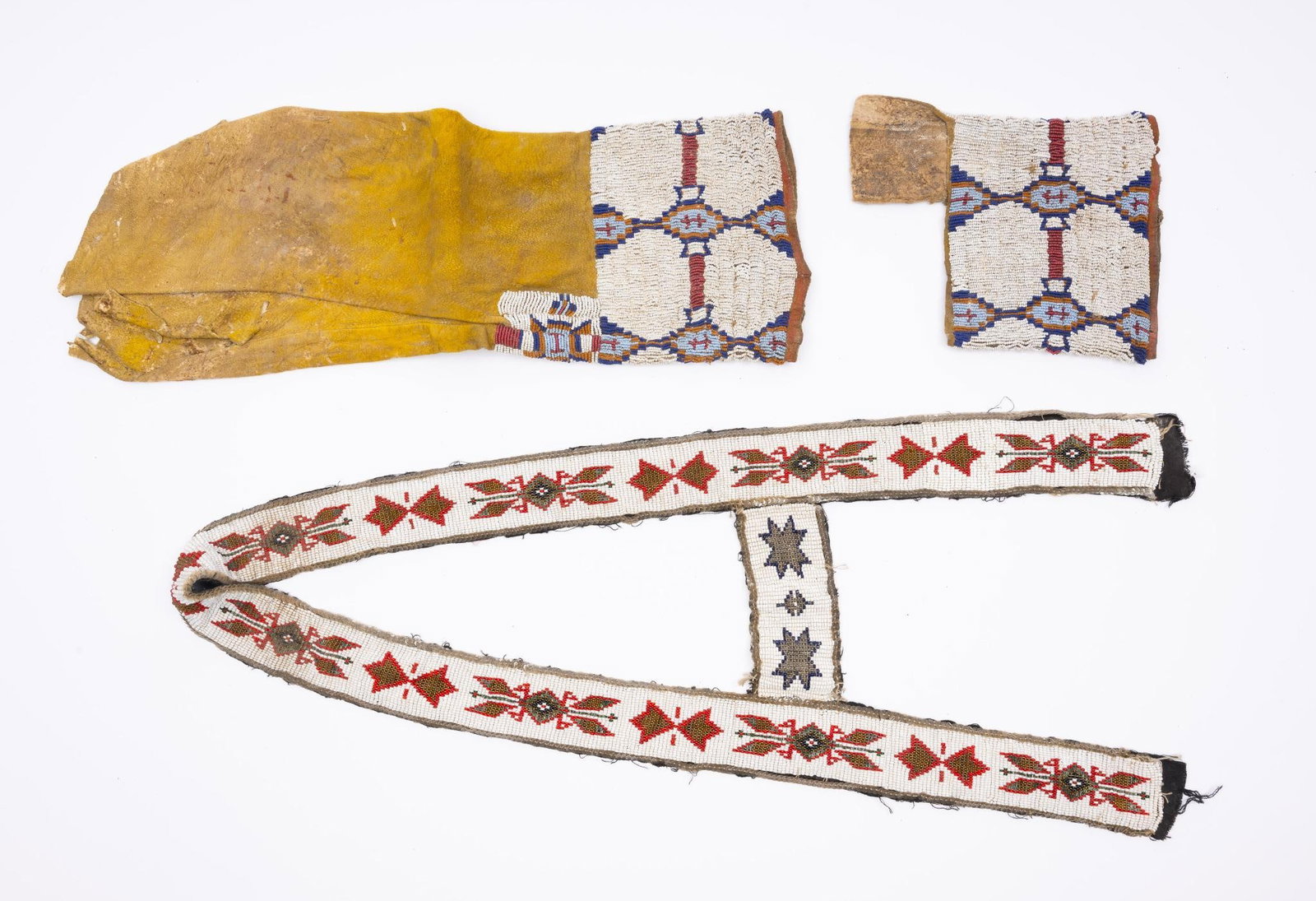 A Pair of Cheyenne Beaded Leggings and a Beadwork Strip: A pair of Cheyenne beaded leggings (one missing part of the hide legging but the beadwork remains intact) and a beaded strip possibly part of a decorated pony trapping. Measurements: Beadwork Strip -