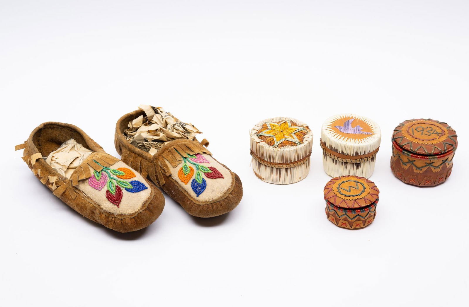 4 Baskets and Pair of Moccasins: A group of four quilled baskets. One identified as Cree and the others Eastern Woodland. Accompanied by a pair of Athabaskan or Athapascan beaded moccasins. Measurements: baskets: 1-1/2" to 2-3/4". mo