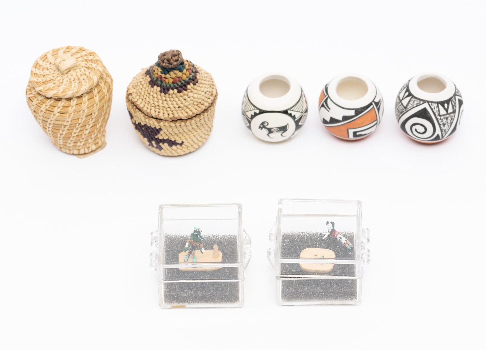 A Group of 7 American Indian Miniatures incl Isleta pottery: A group of seven Native American miniatures including three signed miniature polychrome pots from Isleta Pueblo. In addition two miniature Katsina figures in mounts and two small coiled baskets. Measu